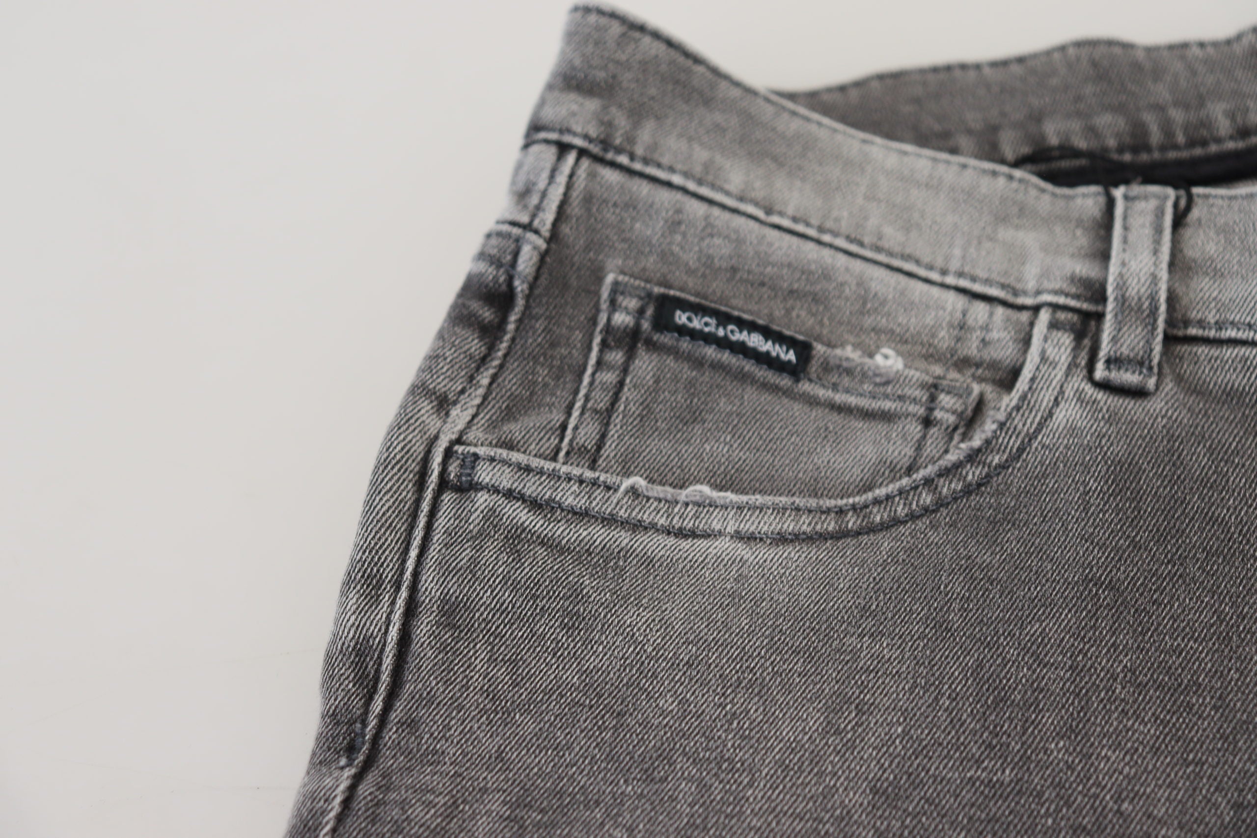 Grey washed cotton skinny denim jeans by Dolce & Gabbana, shown with a close-up of the fitted style and distressed details.