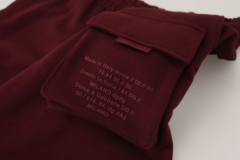 Maroon Dolce & Gabbana men's Bermuda cargo shorts with pockets, casual fit, and waist drawstring, displayed on a hanger.