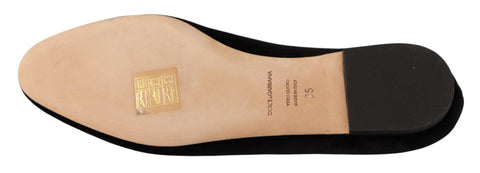 Black Dolce & Gabbana Sacred Heart patch slip-on flats with rounded toe and flat sole, showcasing detailed embroidery and stylish design.