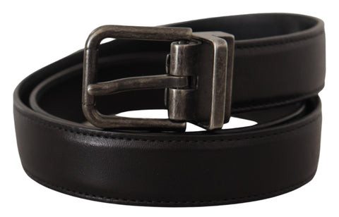 Black calf leather belt with silver logo metal buckle by Dolce & Gabbana, featuring a sleek design and adjustable strap.