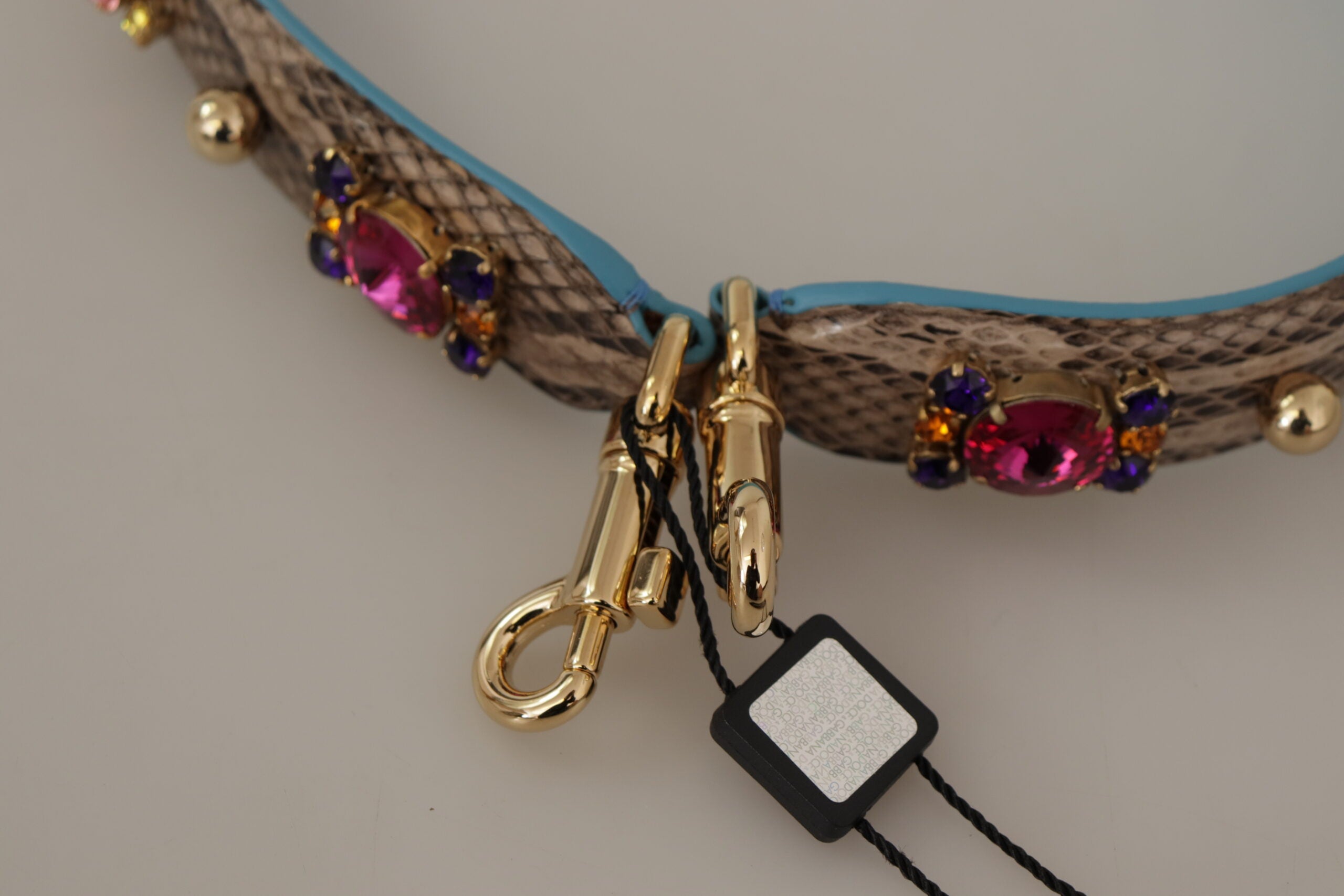 Brown exotic leather shoulder strap with decorative crystals, designed by Dolce & Gabbana, featuring intricate detailing and a luxurious finish.