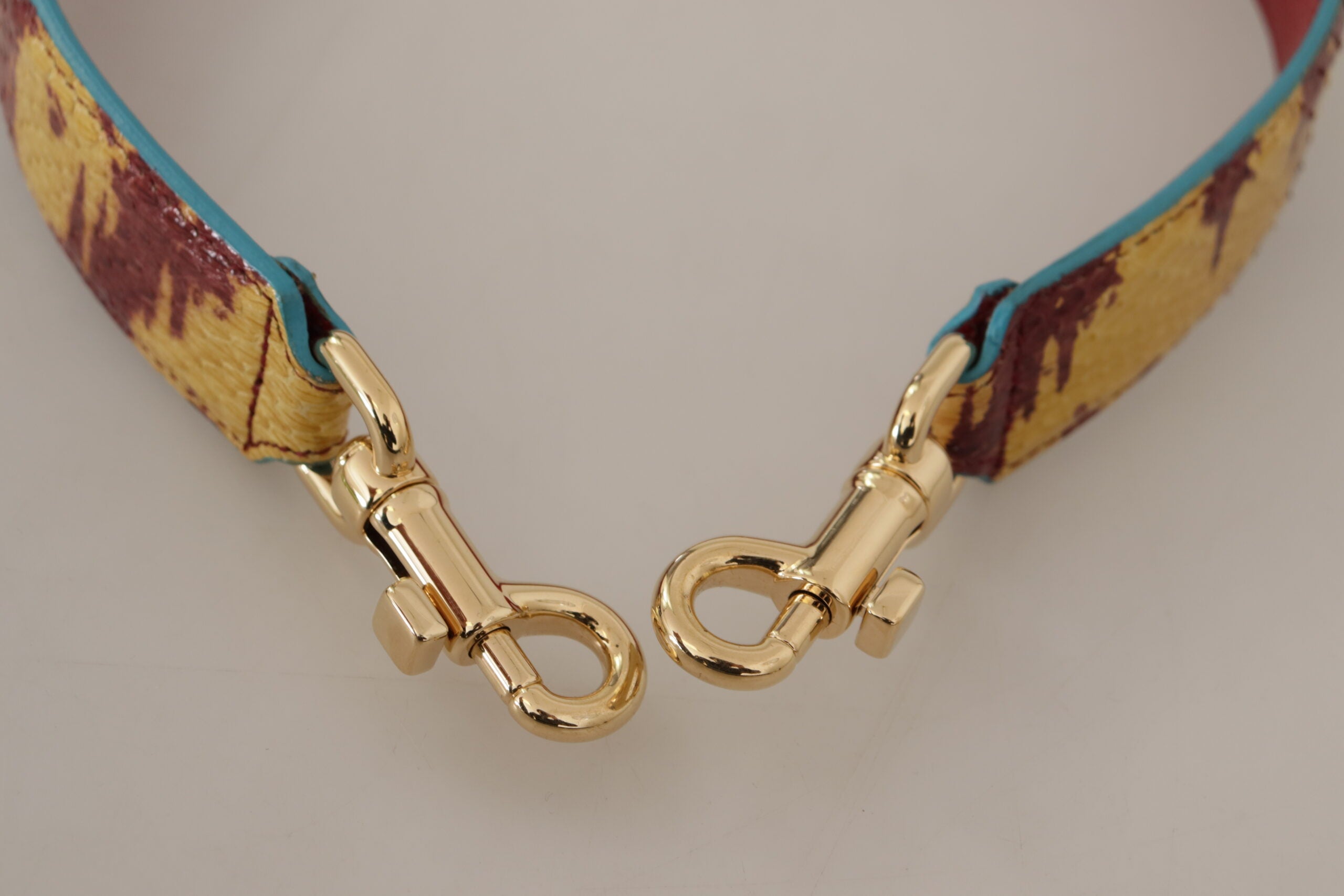 Yellow and red leather shoulder strap with gold tone hardware, designed by Dolce & Gabbana.