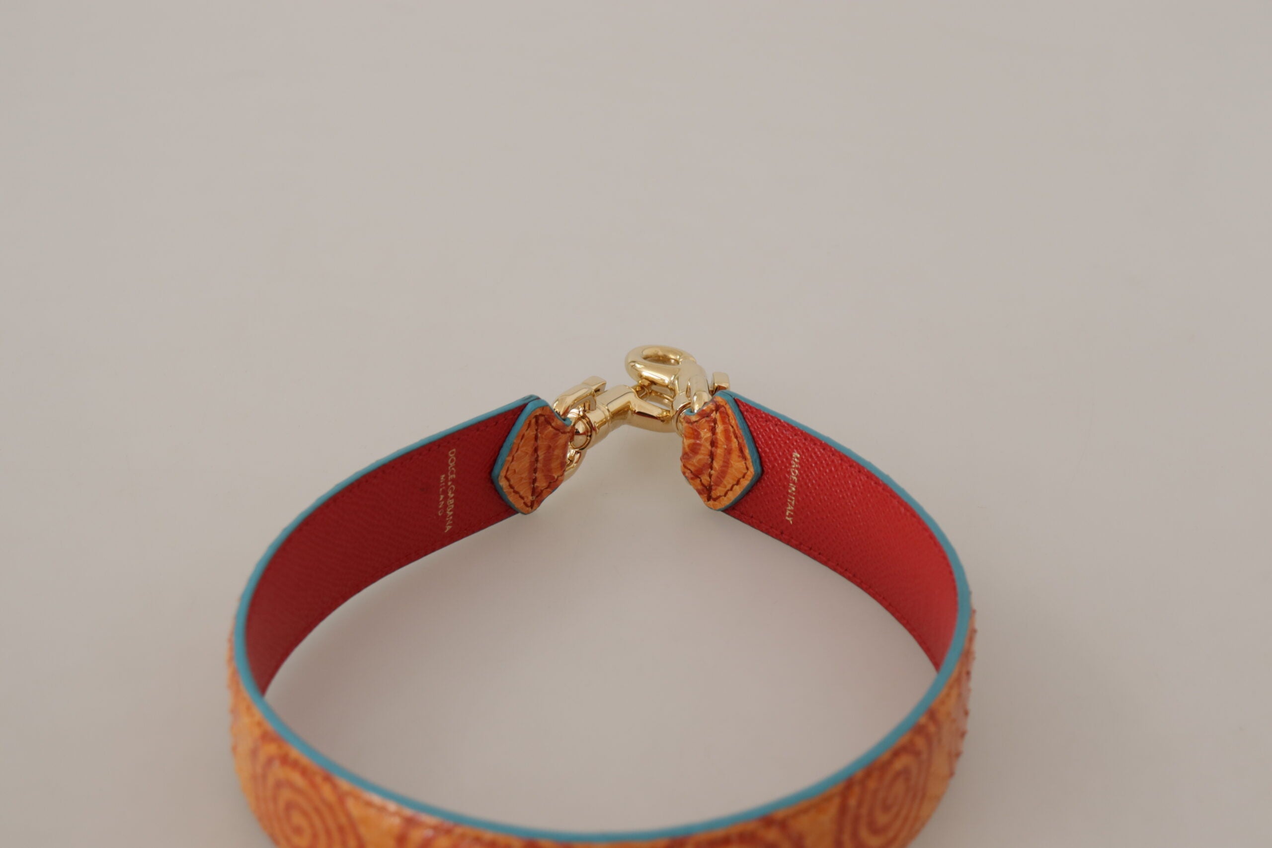 Orange leather swirl print bag shoulder strap by Dolce & Gabbana with gold-tone hardware and adjustable length.