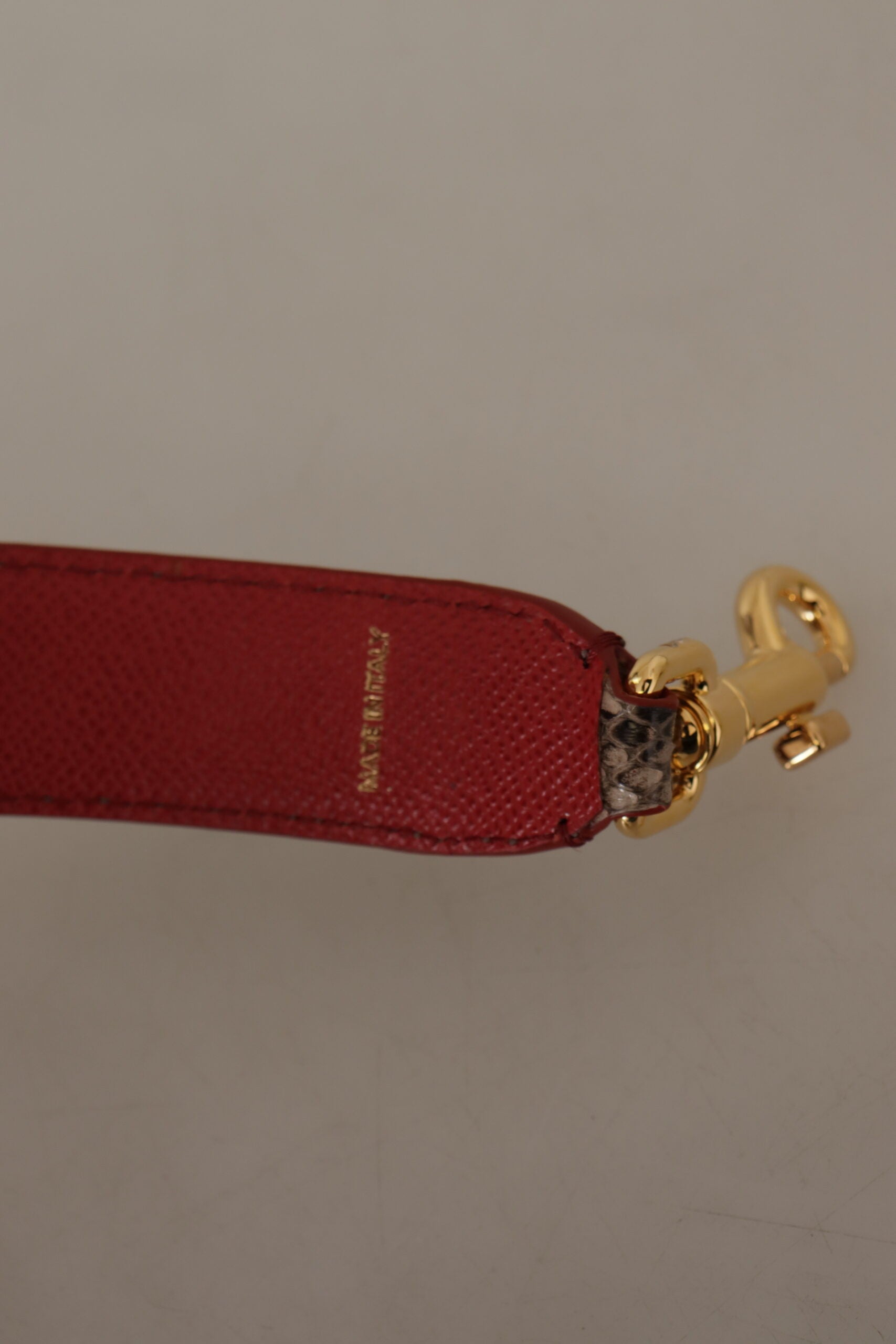 Brown Python leather shoulder strap with gold studs from Dolce & Gabbana, featuring textured python skin and adjustable length.