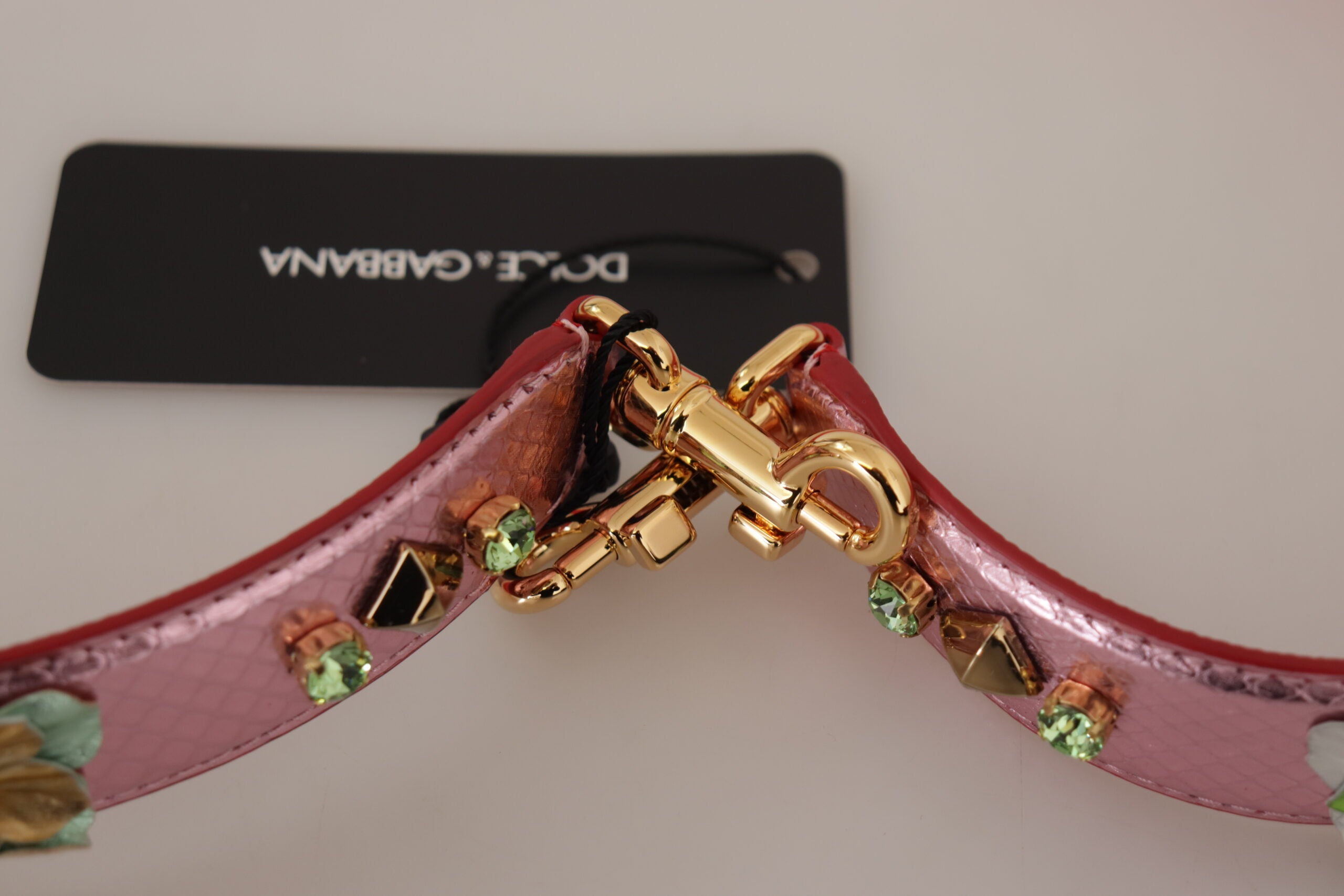 Pink metallic leather shoulder strap with stud accents by Dolce & Gabbana, featuring adjustable length and silver hardware.