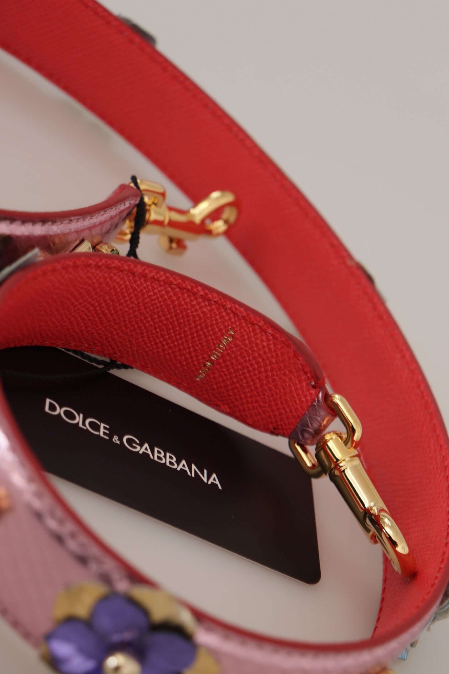 Metallic pink leather shoulder strap with stud detailing from Dolce & Gabbana, showcasing textured leather and silver-tone studs.
