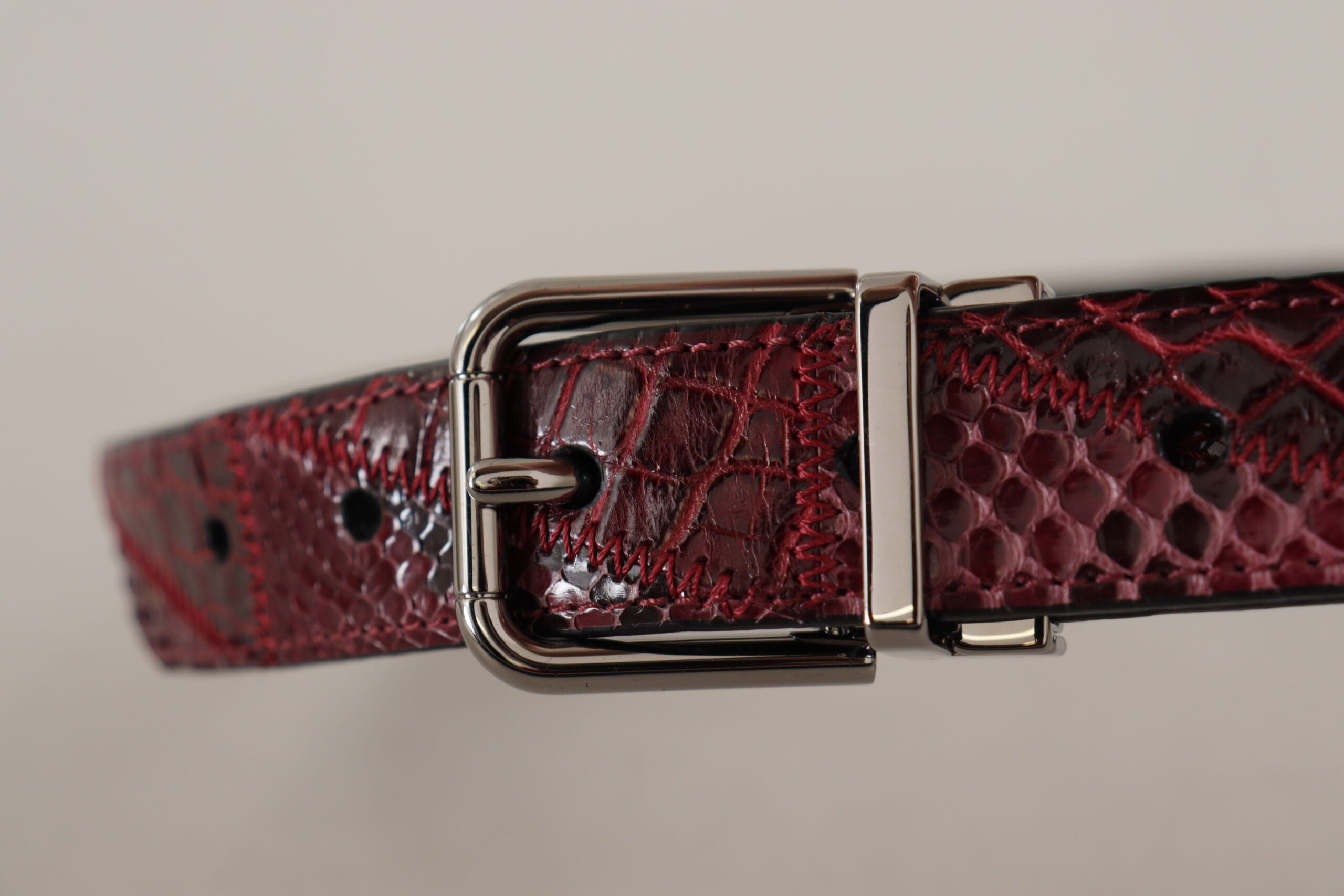 Red exotic leather belt with metal logo buckle by Dolce & Gabbana, featuring a sleek and luxurious design.