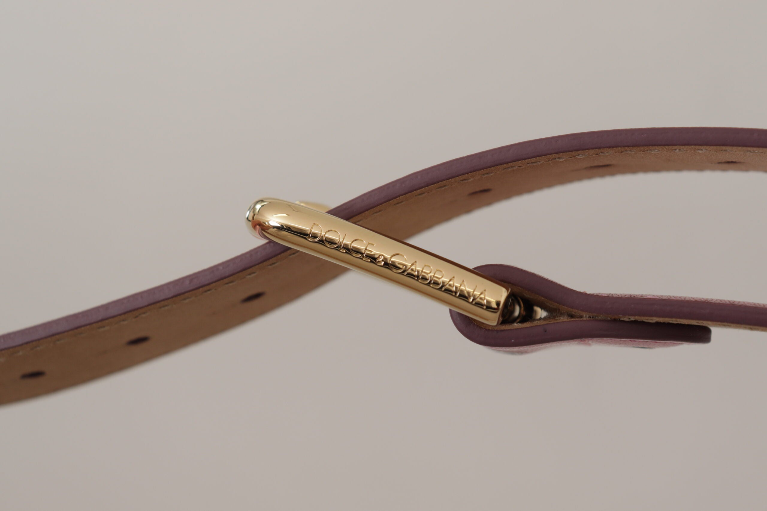 Metallic pink polished leather belt with Dolce & Gabbana logo metal buckle, stylish accessory with a glossy finish.