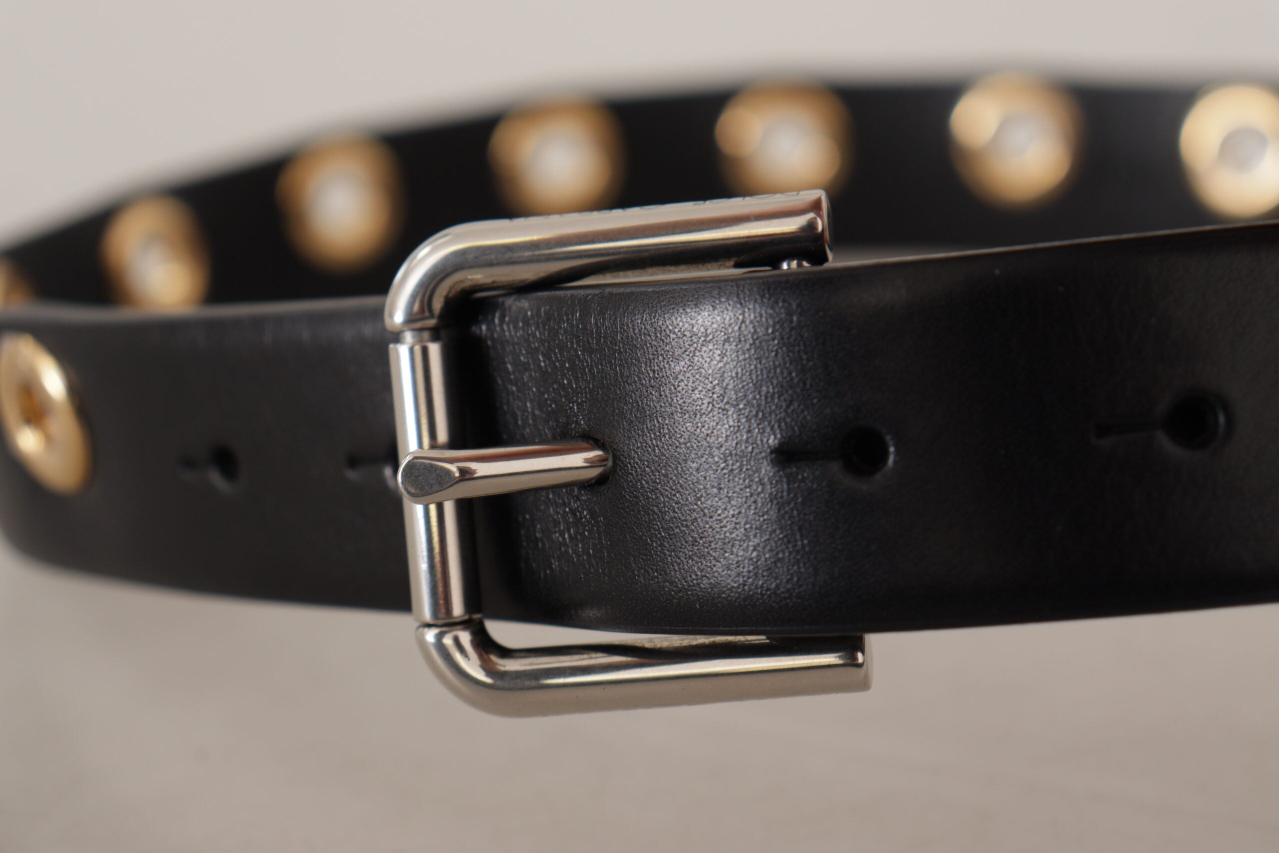 Black leather belt with silver eyelet and metal buckle by Dolce & Gabbana, featuring a sleek, stylish design.