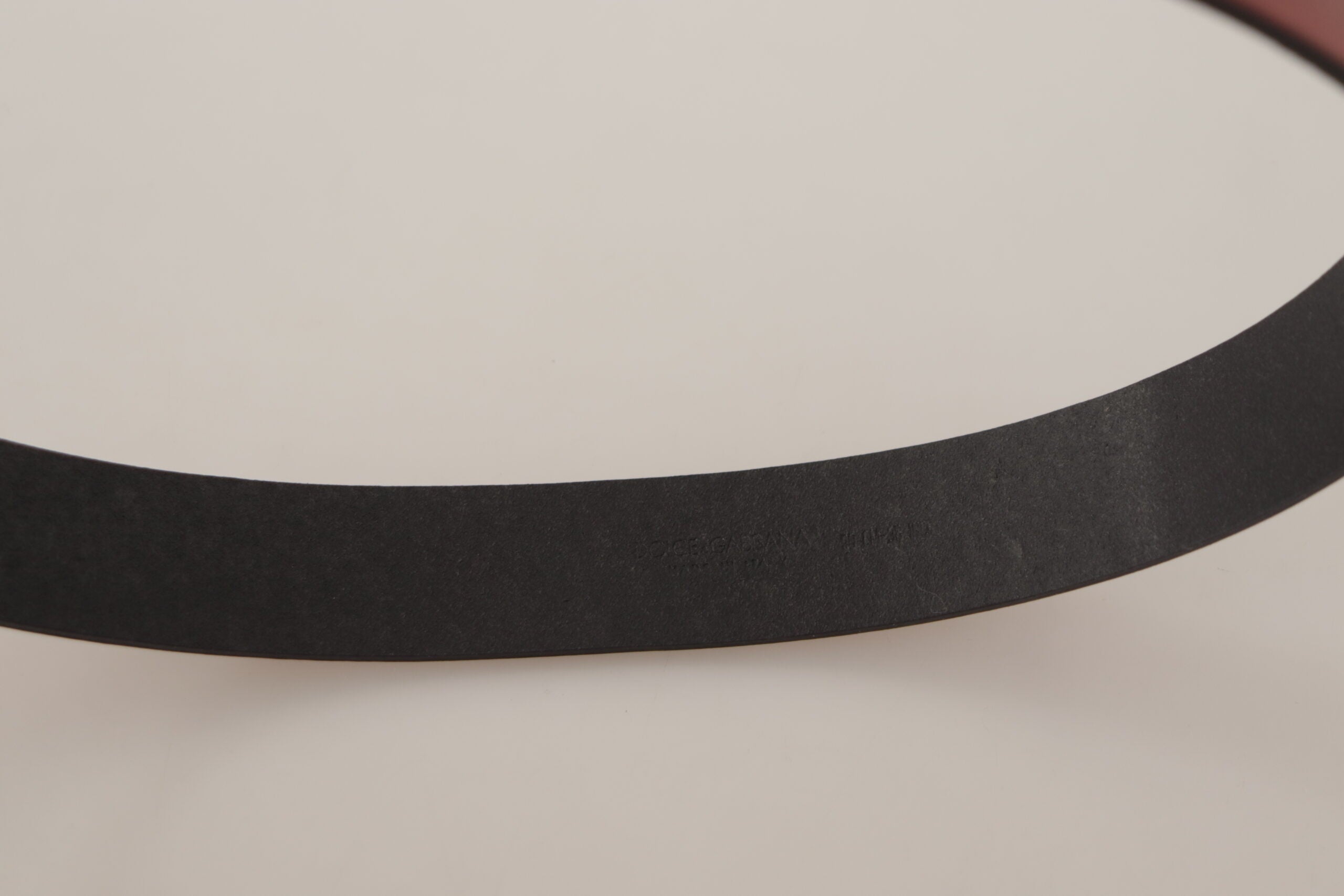 Red leather belt by Dolce & Gabbana with a gold logo engraved metal buckle, stylish accessory with a sleek design.