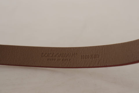 Brown leather belt with engraved metal waist buckle featuring Dolce & Gabbana logo and detailing.