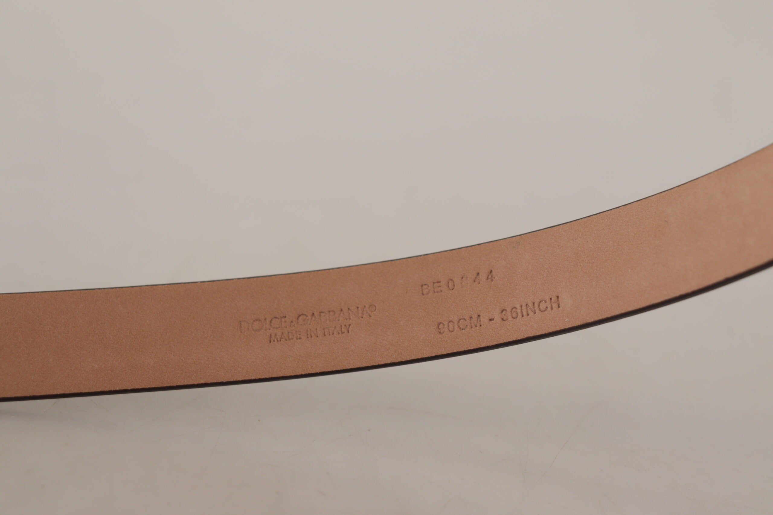 Black patent leather belt with metal logo buckle from Dolce & Gabbana, featuring a sleek design and shiny finish.