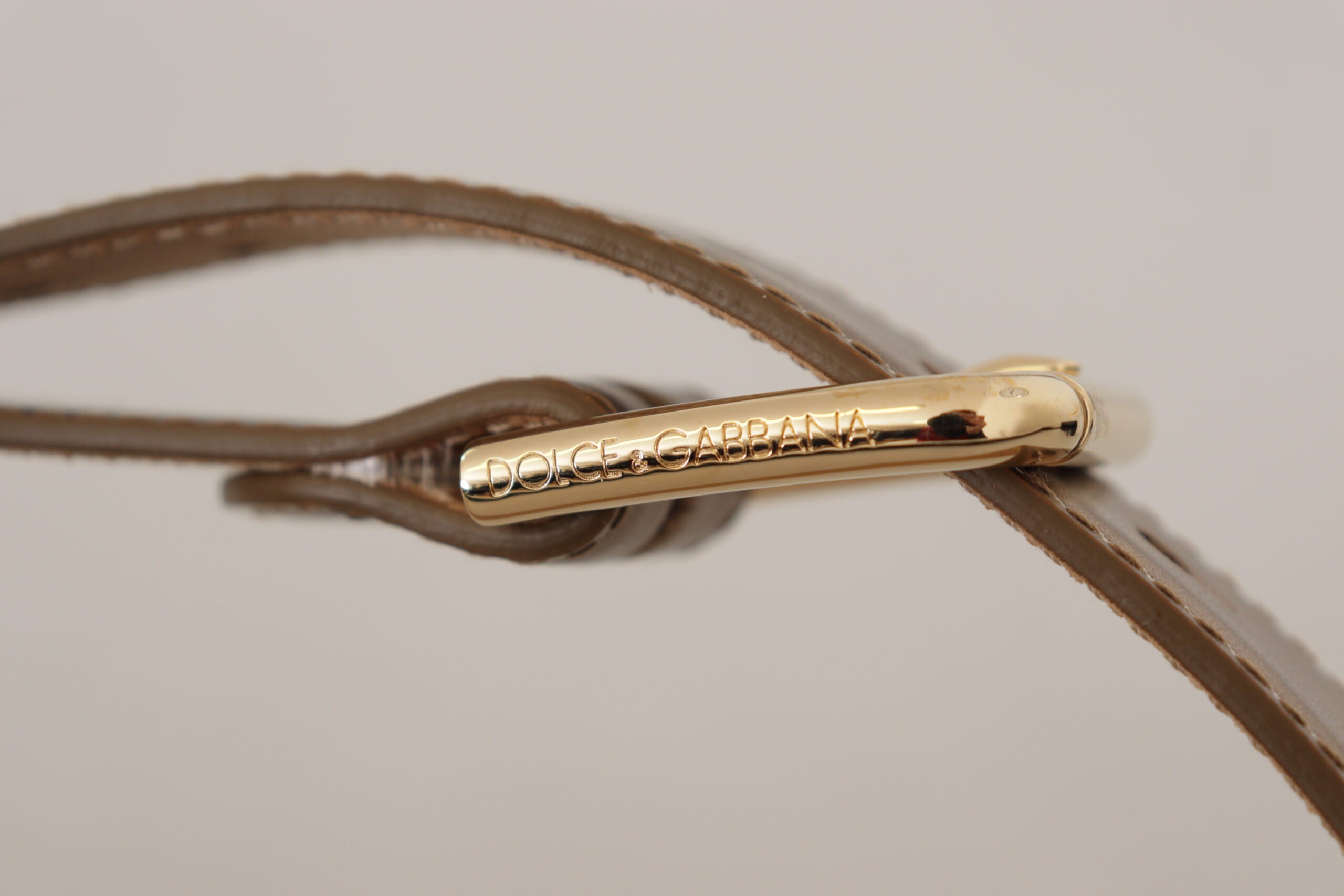 Bronze leather waist belt with gold logo engraved buckle, stylish and luxurious Dolce & Gabbana accessory.