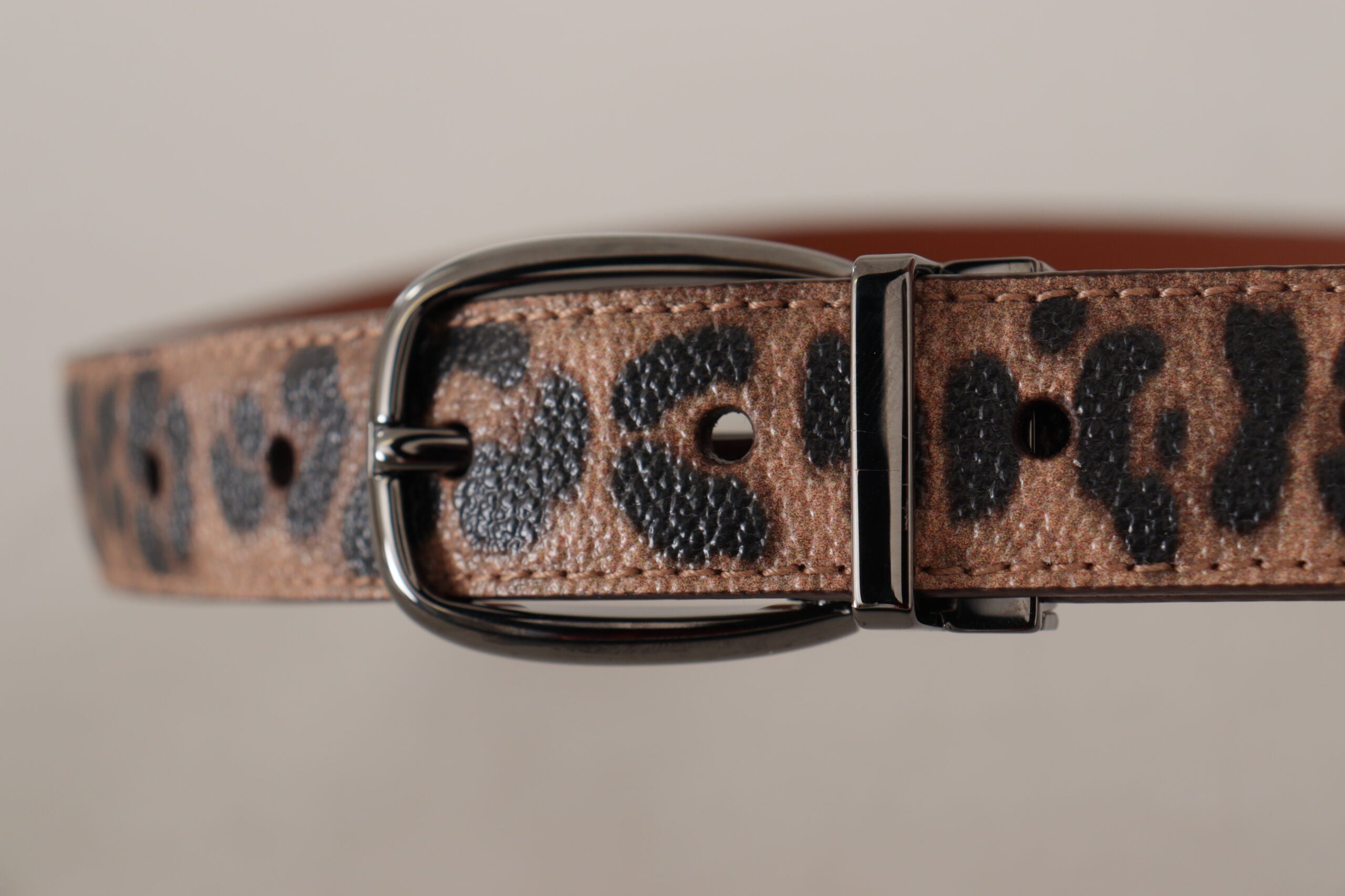 Brown leather belt with leopard embossed pattern and buckle, by Dolce & Gabbana, showcasing detailed texture and stylish design.
