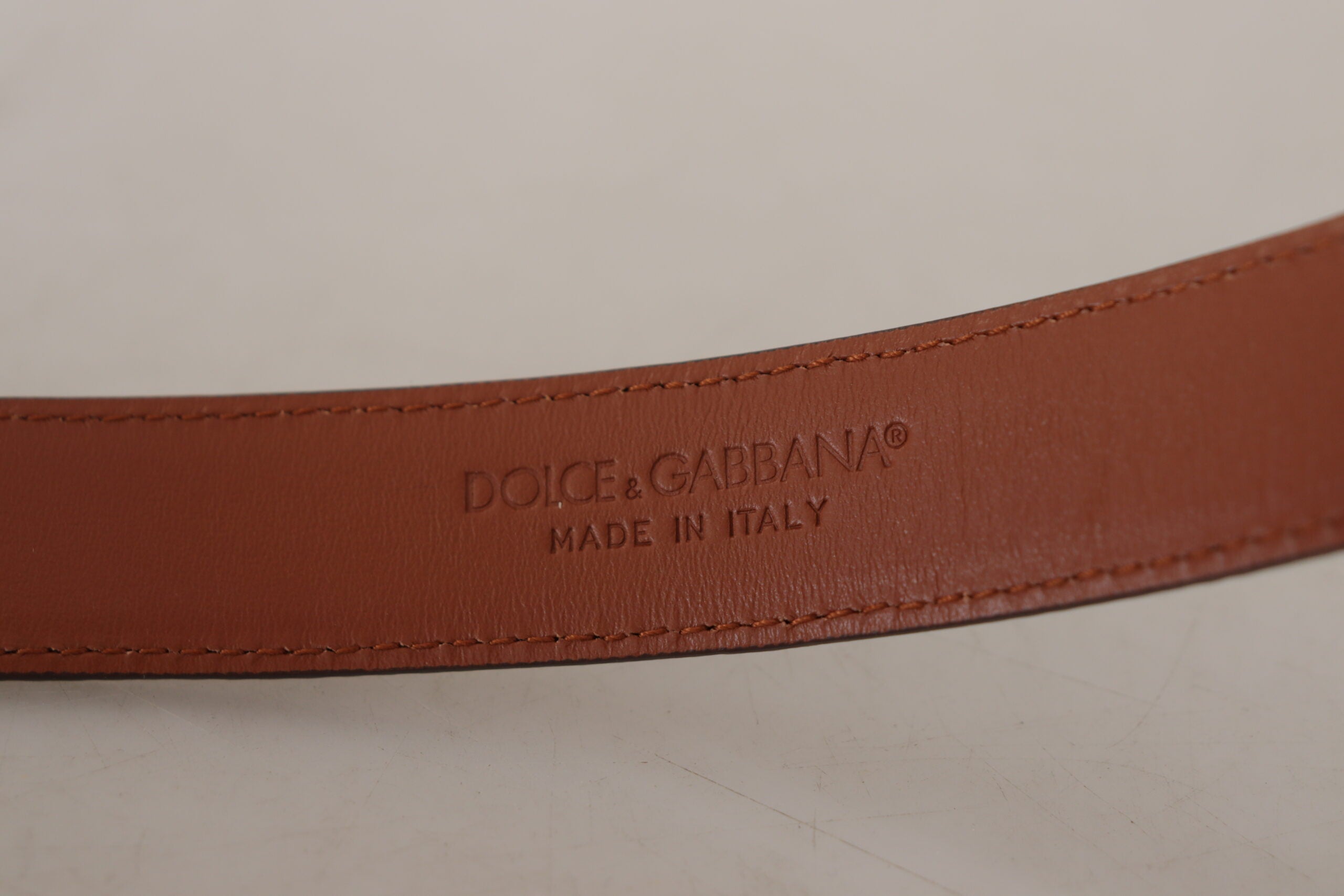 Brown leather belt with leopard embossing and buckle, by Dolce & Gabbana, featuring textured animal print design.