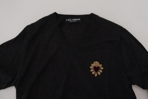 Gray cashmere V-neck sweater with gold heart detail by Dolce & Gabbana, shown on a model.