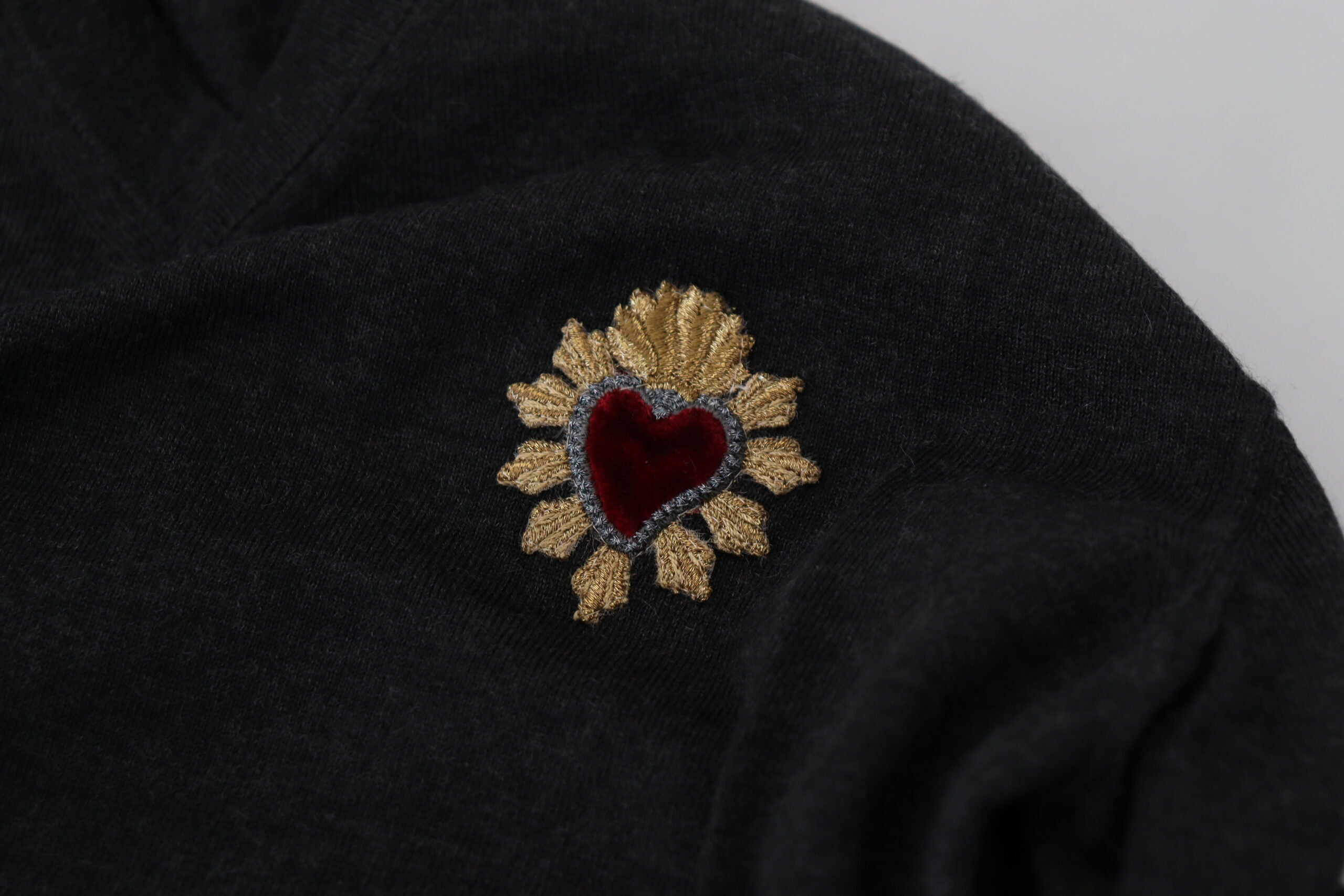 Gray cashmere V-neck sweater with gold heart detail by Dolce & Gabbana, showing the soft texture and stylish design.