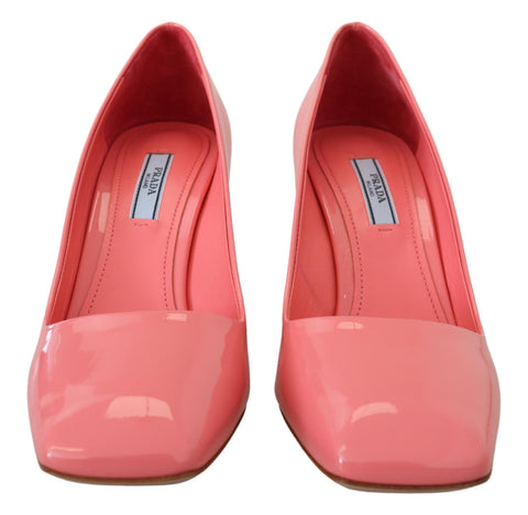 Pink patent leather Prada block heel pumps with classic design, featuring a sleek pointed toe and stylish high heel.