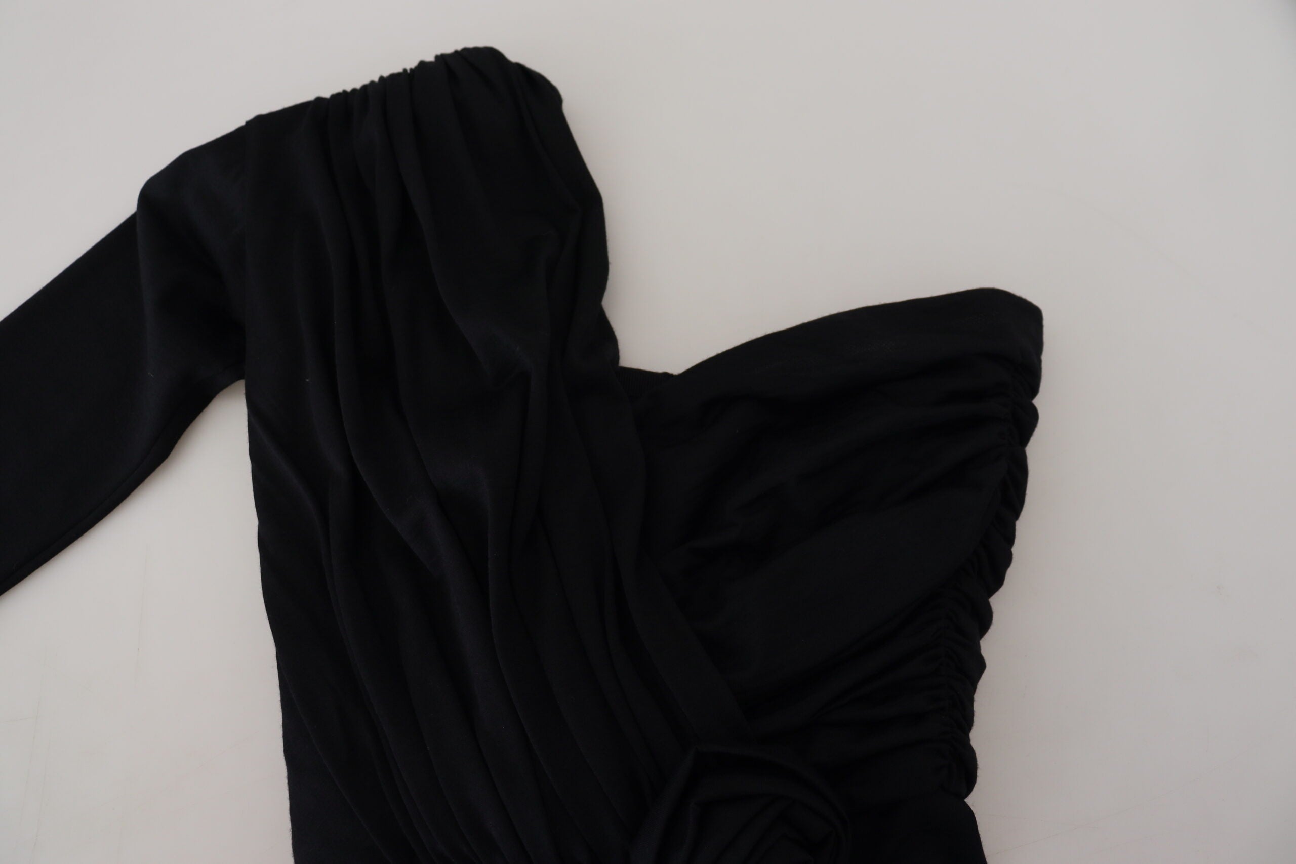 Black wrap sheath wool dress with one-shoulder design by Dolce & Gabbana, shown on a mannequin.