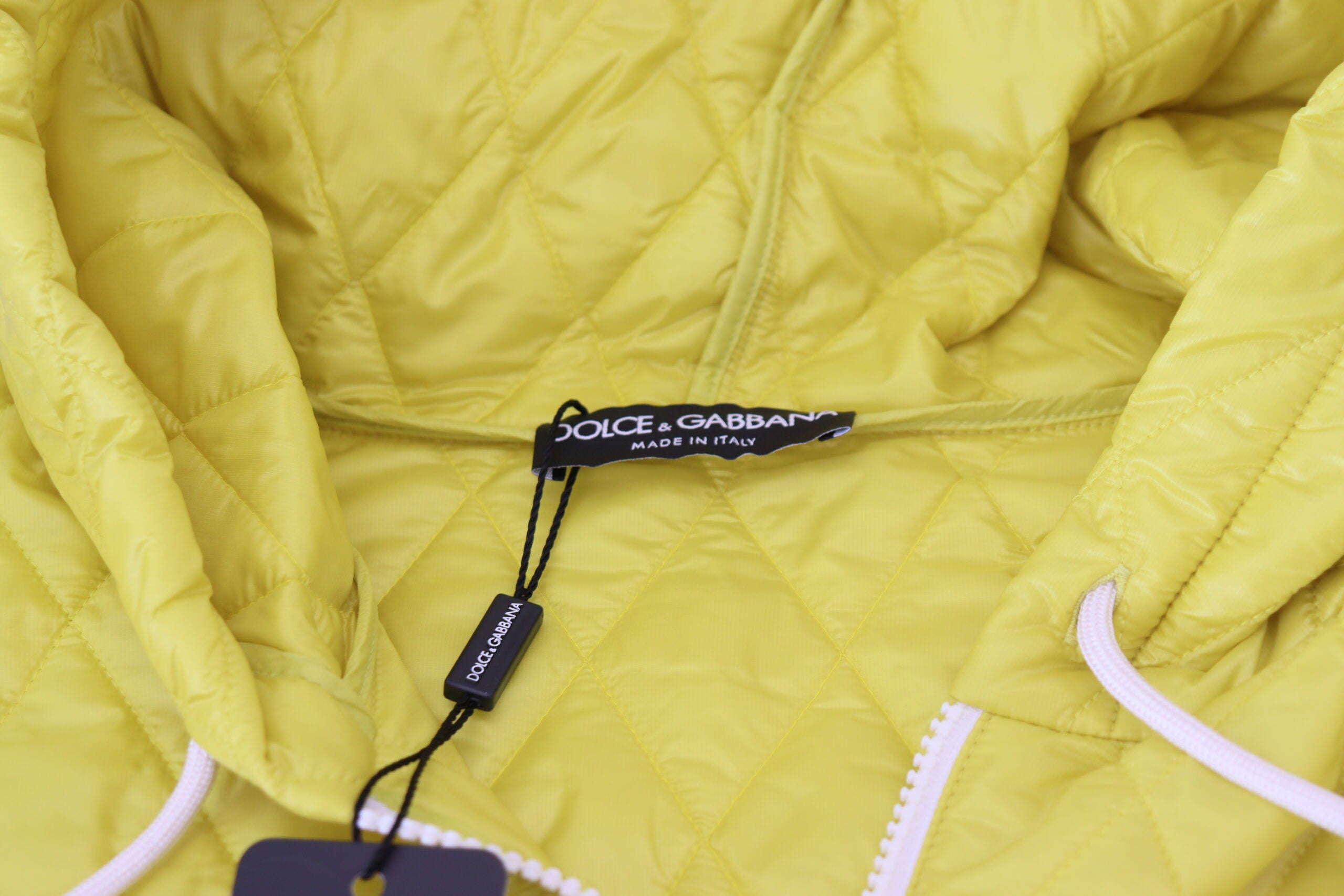 Yellow nylon quilted hooded pullover jacket by Dolce & Gabbana with quilted texture and adjustable hood.