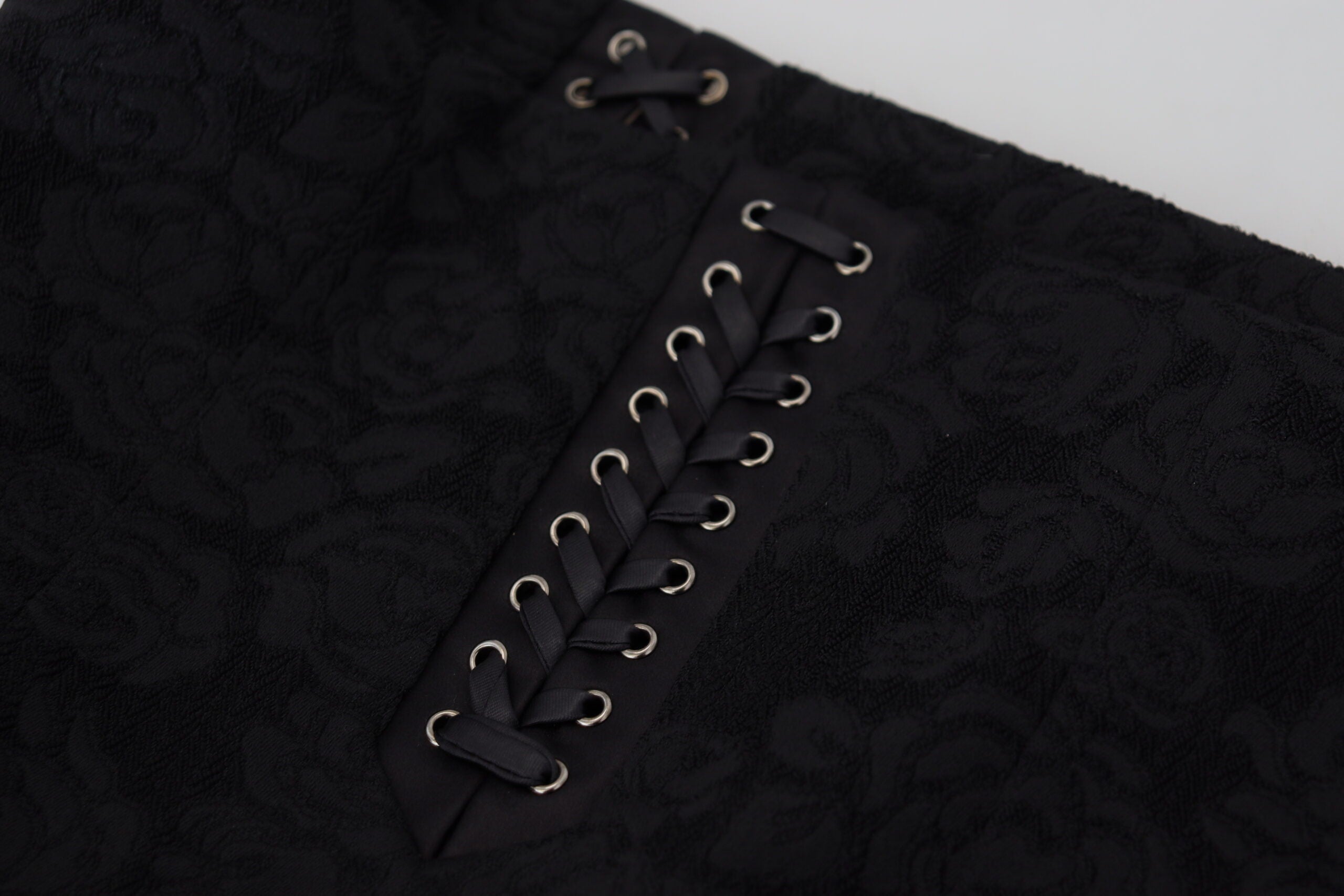 Black brocade mini pencil skirt by Dolce & Gabbana, above knee length with intricate floral pattern and fitted silhouette.
