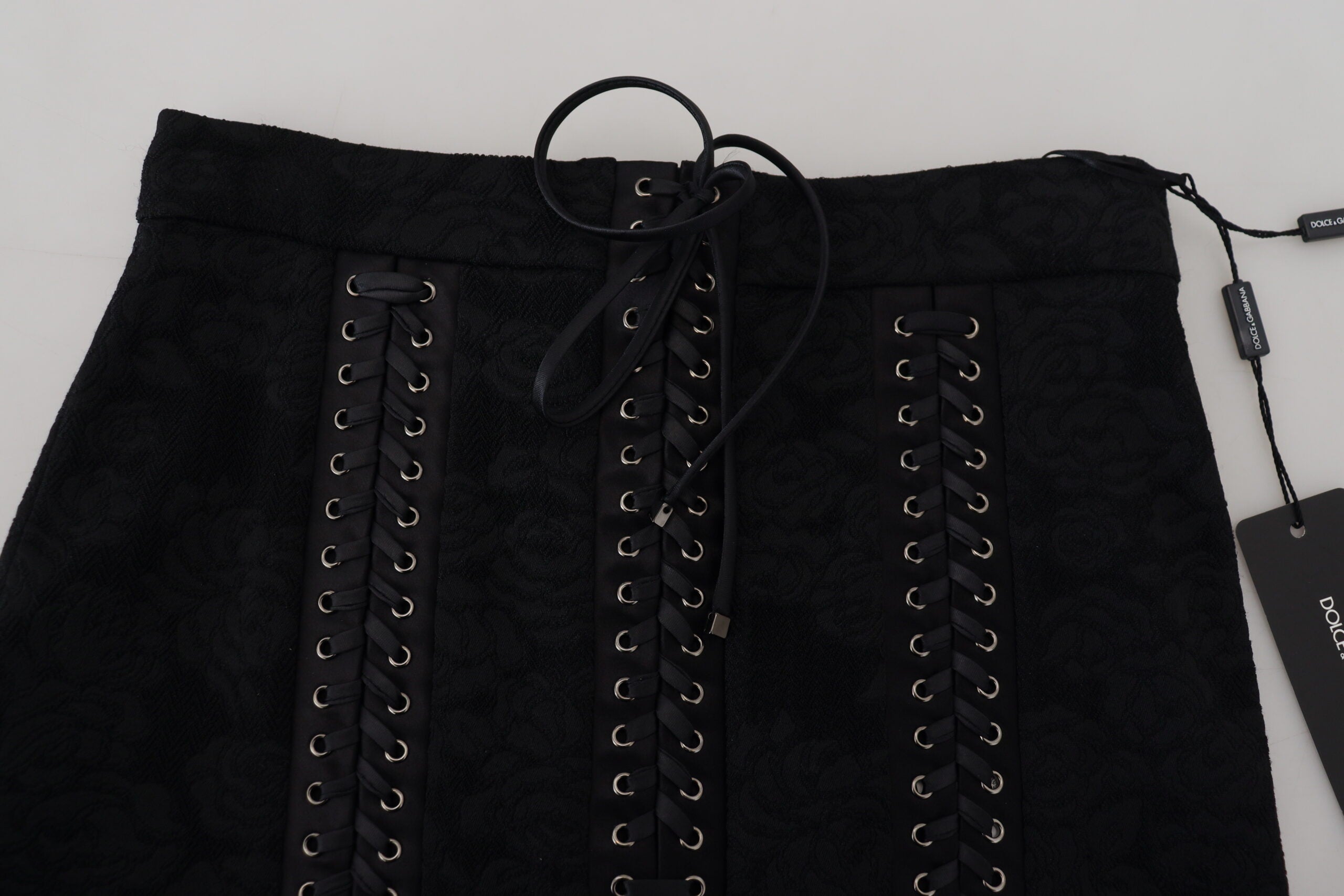 Black brocade mini pencil skirt by Dolce & Gabbana with above-the-knee length and intricate floral pattern.