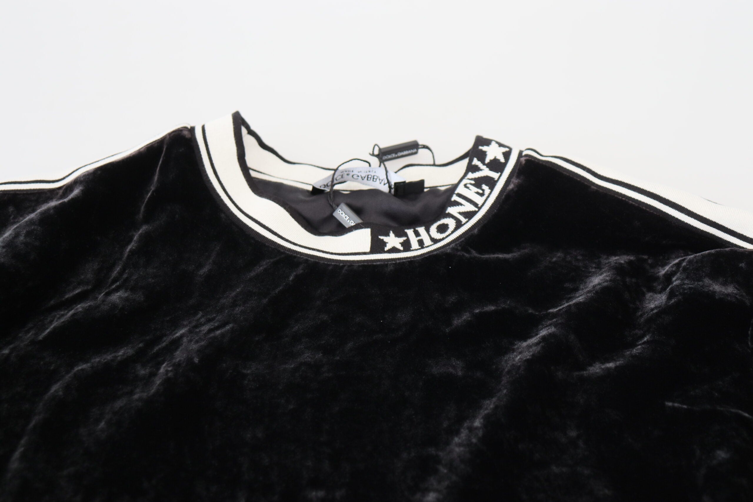 Black velvet crewneck pullover sweater by Dolce & Gabbana, close-up of soft fabric and classic fit.