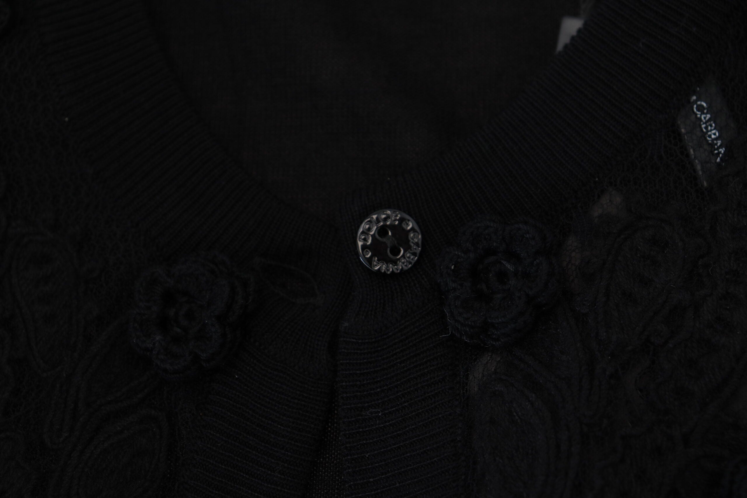 Black floral lace cardigan sweater by Dolce & Gabbana with buttons, featuring intricate lace detailing and a fitted design.