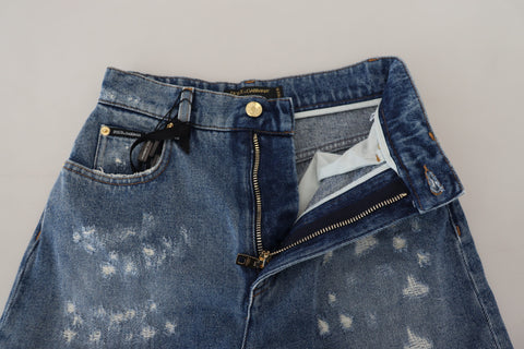 Blue tattered skinny denim cotton jeans by Dolce & Gabbana shown on a model. Slim fit with distressed details and classic five-pocket design.