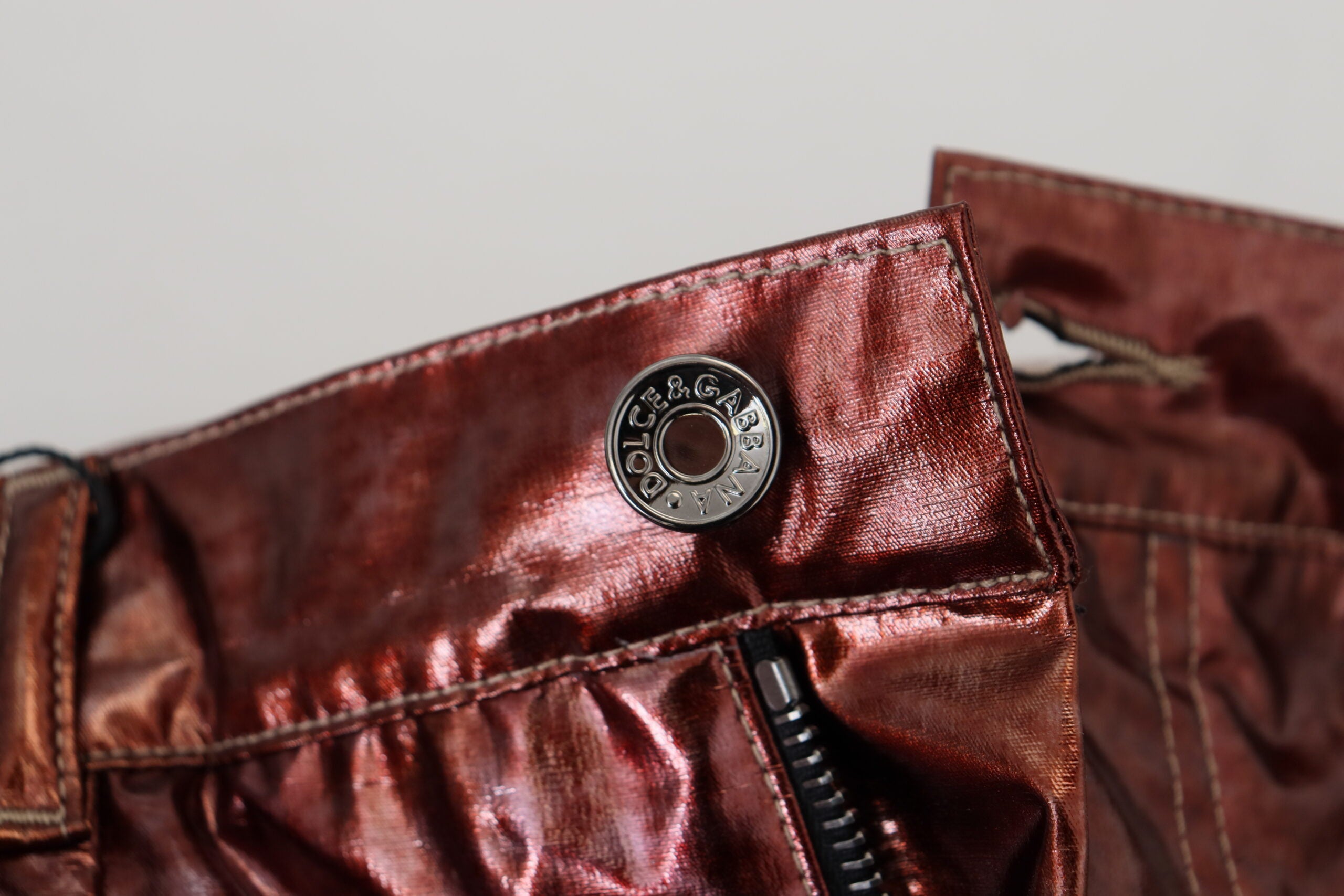Metallic bronze high waist skinny jeans by Dolce & Gabbana, showing close-up of fitted denim with shiny finish.