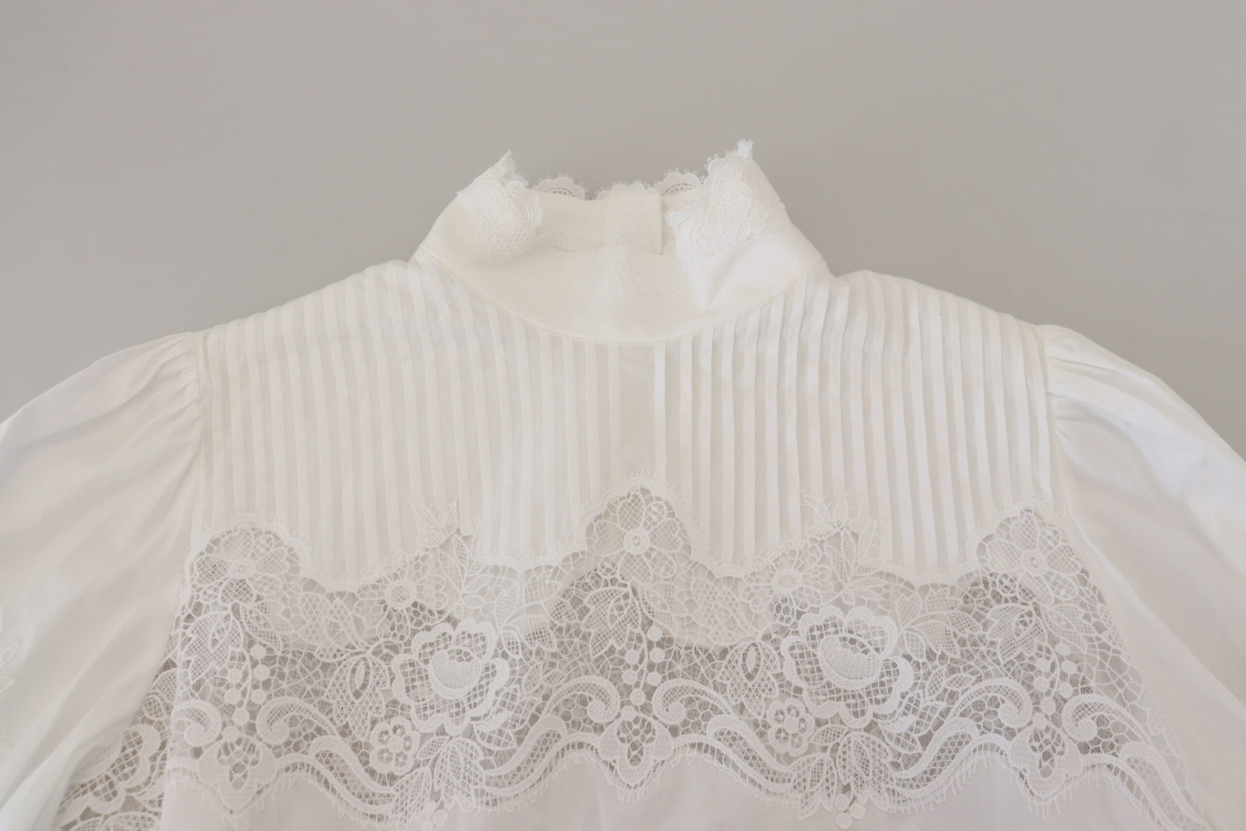 White cotton blouse with lace trim and turtle neck by Dolce & Gabbana, featuring a stylish, elegant design.