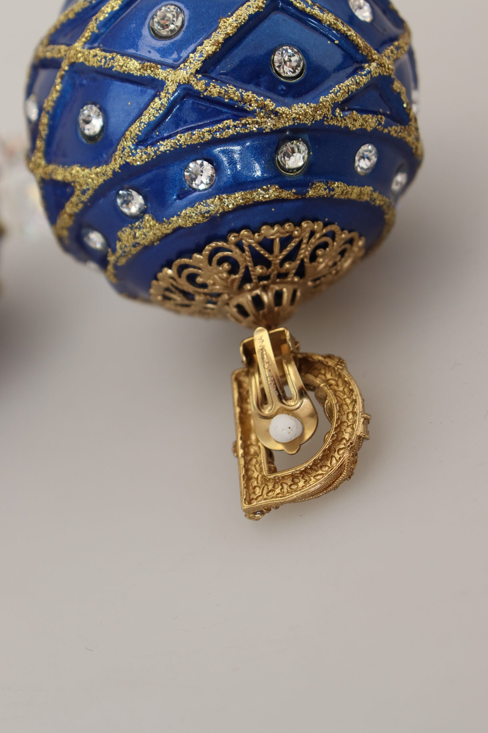 Gold brass and blue dangle ball crystal clip-on earrings by Dolce & Gabbana, featuring elegant hanging design and sparkling accents.
