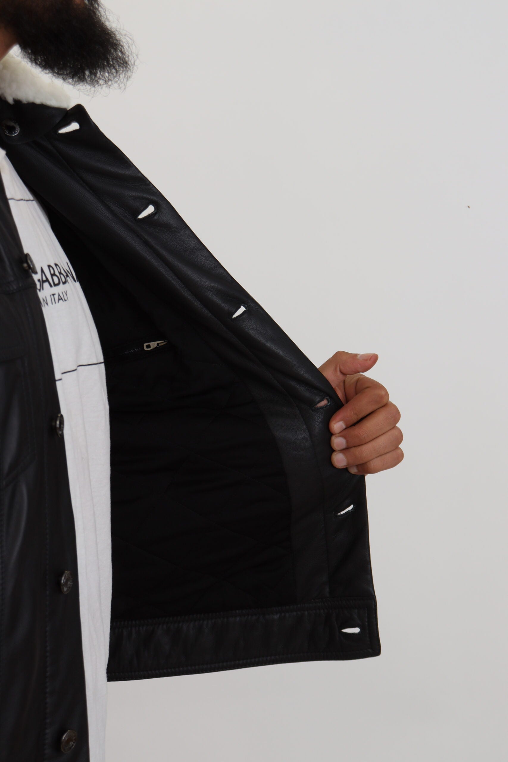 Black lamb leather men's coat with a collar, designed by Dolce & Gabbana, shown on a hanger against a neutral background.
