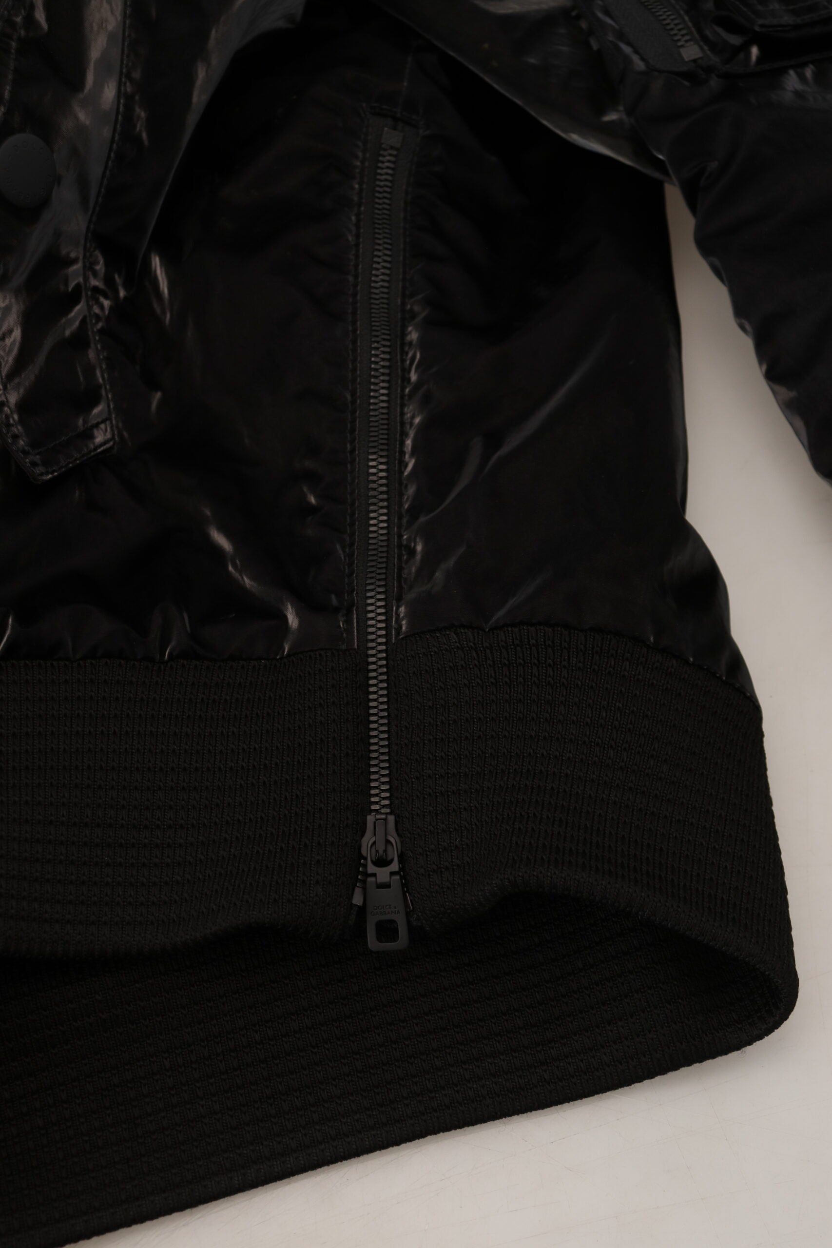 Black nylon hooded full zip bomber jacket by Dolce & Gabbana, featuring a sleek design and hooded collar.