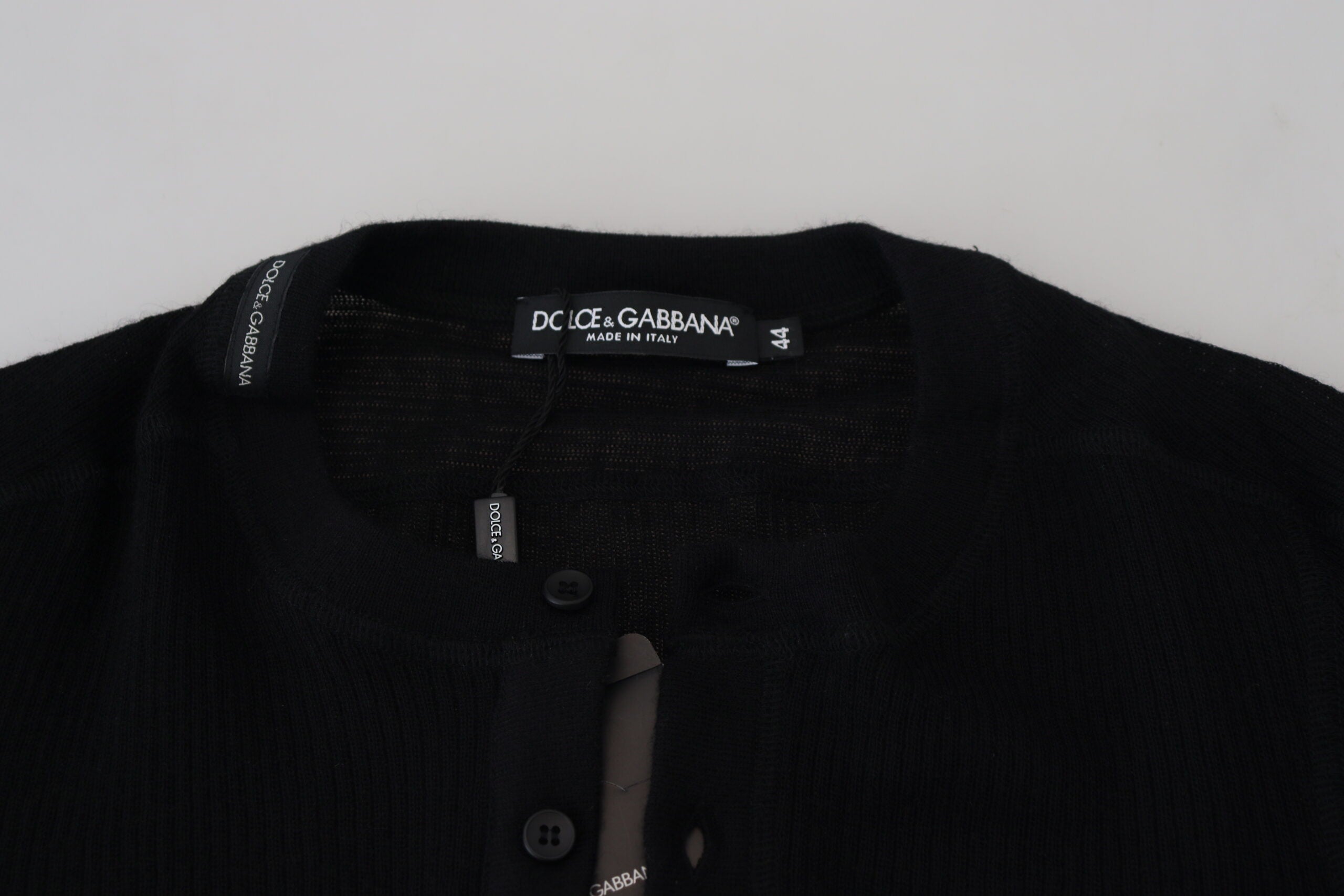 Black cashmere Dolce & Gabbana button pullover sweater, close-up showing soft texture and stylish design.