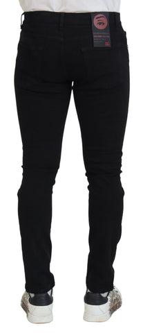 Black slim fit tattered denim cotton jeans by Dolce & Gabbana, showing distressed details and classic five-pocket design.