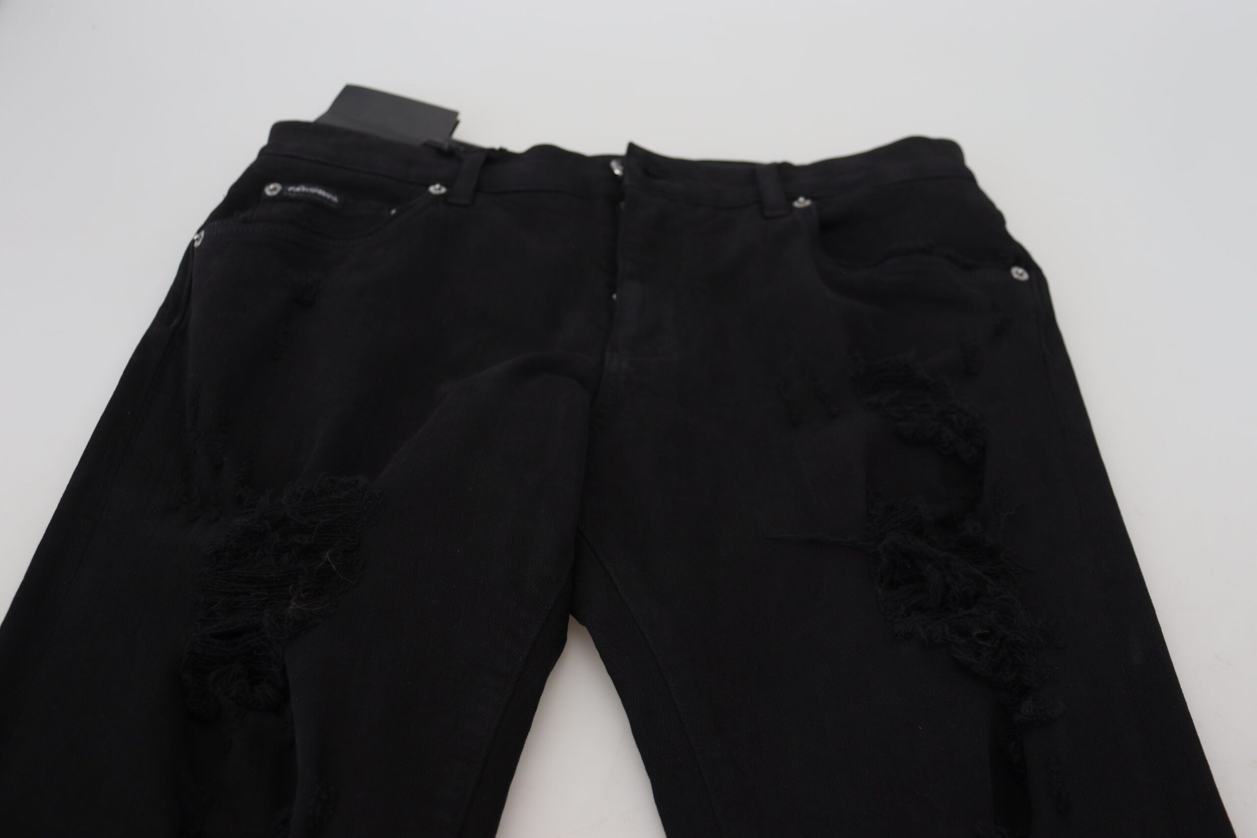 Black slim fit tattered denim cotton jeans by Dolce & Gabbana, shown with distressed details and classic five-pocket design.