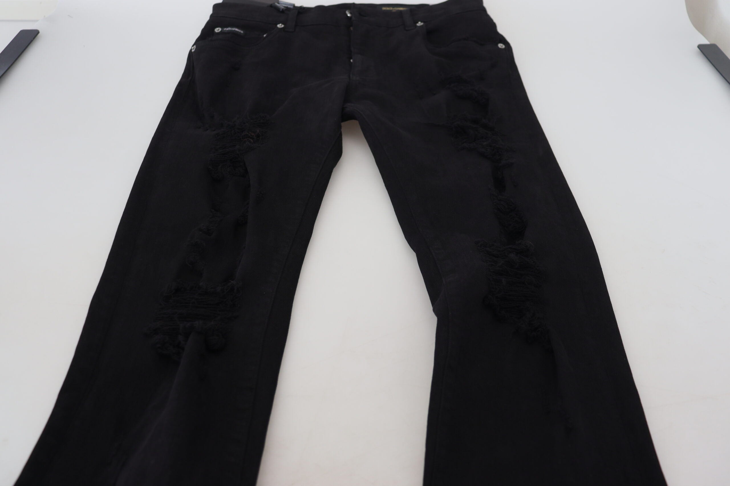 Black slim fit tattered denim cotton jeans by Dolce & Gabbana, showing distressed details and classic five-pocket design.