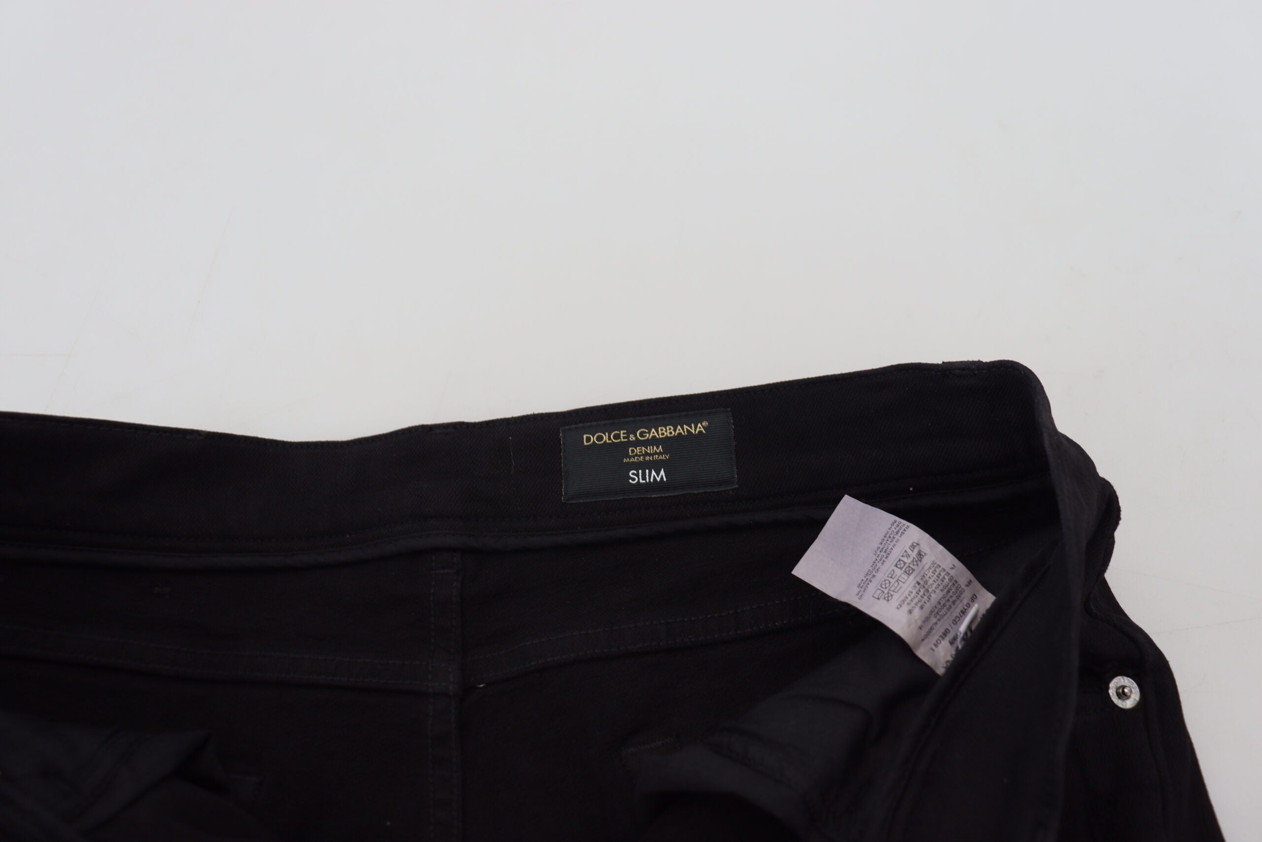 Black slim fit tattered denim cotton jeans by Dolce & Gabbana, shown with distressed details and classic five-pocket design.