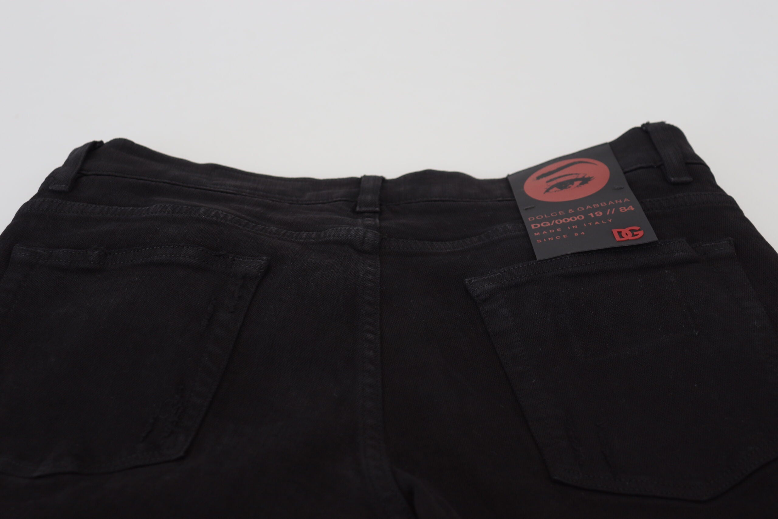 Black slim fit tattered denim cotton jeans by Dolce & Gabbana, featuring distressed details and modern styling.