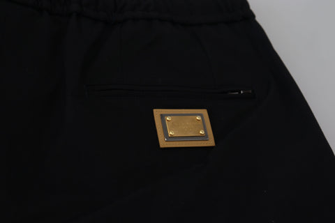 Black cotton cropped pants with elastic waist and DG logo from Dolce & Gabbana, showing a close-up of the fabric and design details.