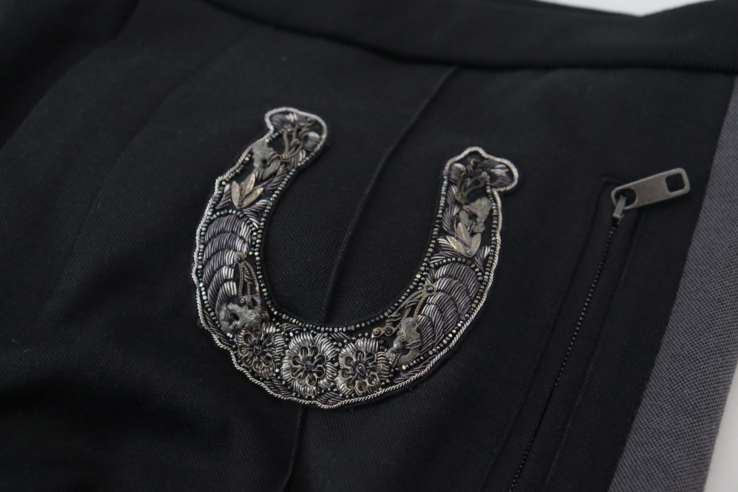 Black wool horseshoe jogger pants by Dolce & Gabbana with a relaxed fit and elastic waistband, displayed on a hanger.