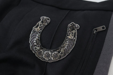 Black wool horseshoe jogger pants by Dolce & Gabbana with a relaxed fit and elastic waistband, displayed on a hanger.