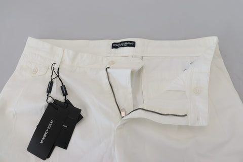 White cotton skinny chino pants by Dolce & Gabbana, shown with a close-up of the fitted waist and sleek fabric texture.