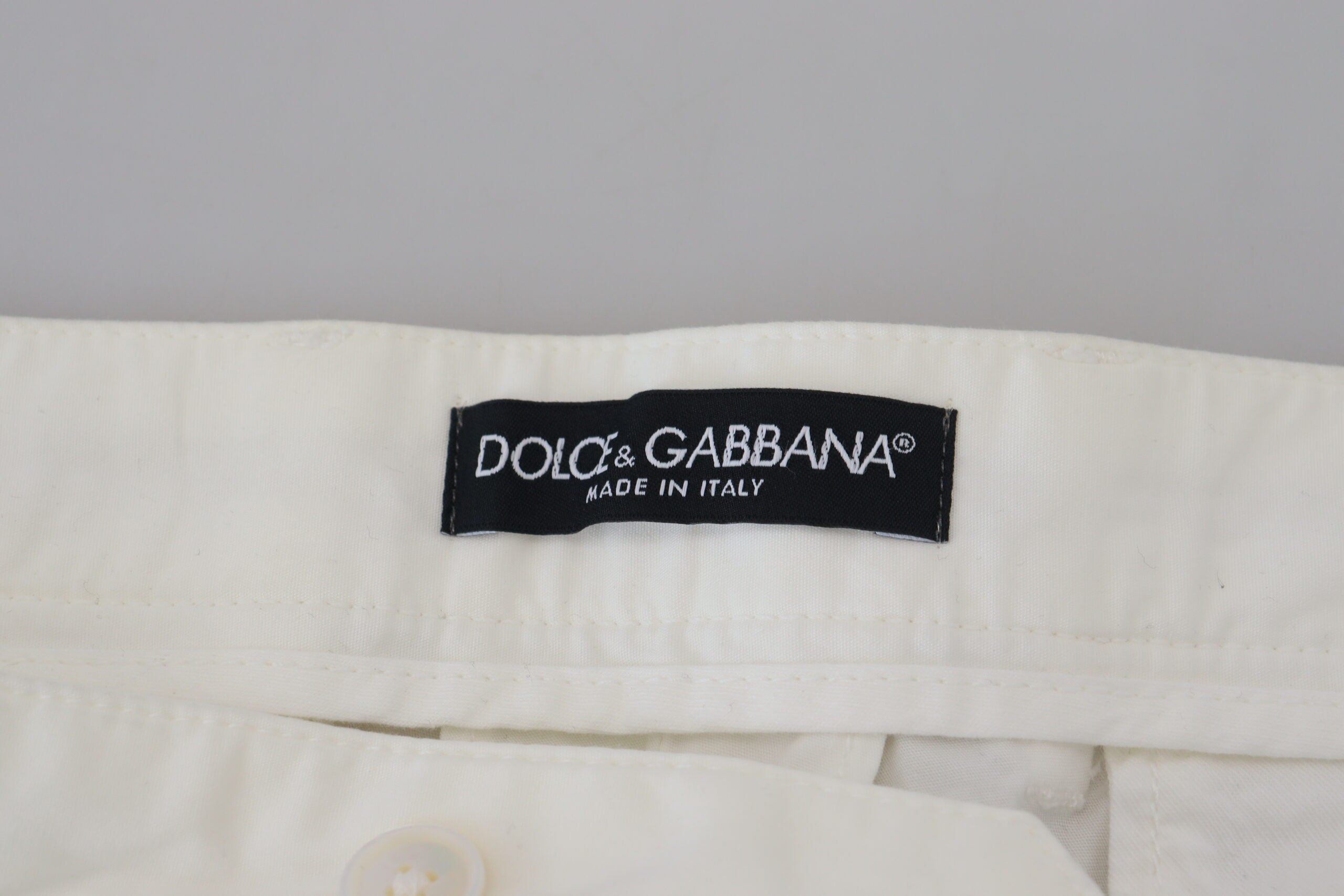 White cotton skinny chino pants by Dolce & Gabbana displayed on a model, showcasing slim fit and classic design.