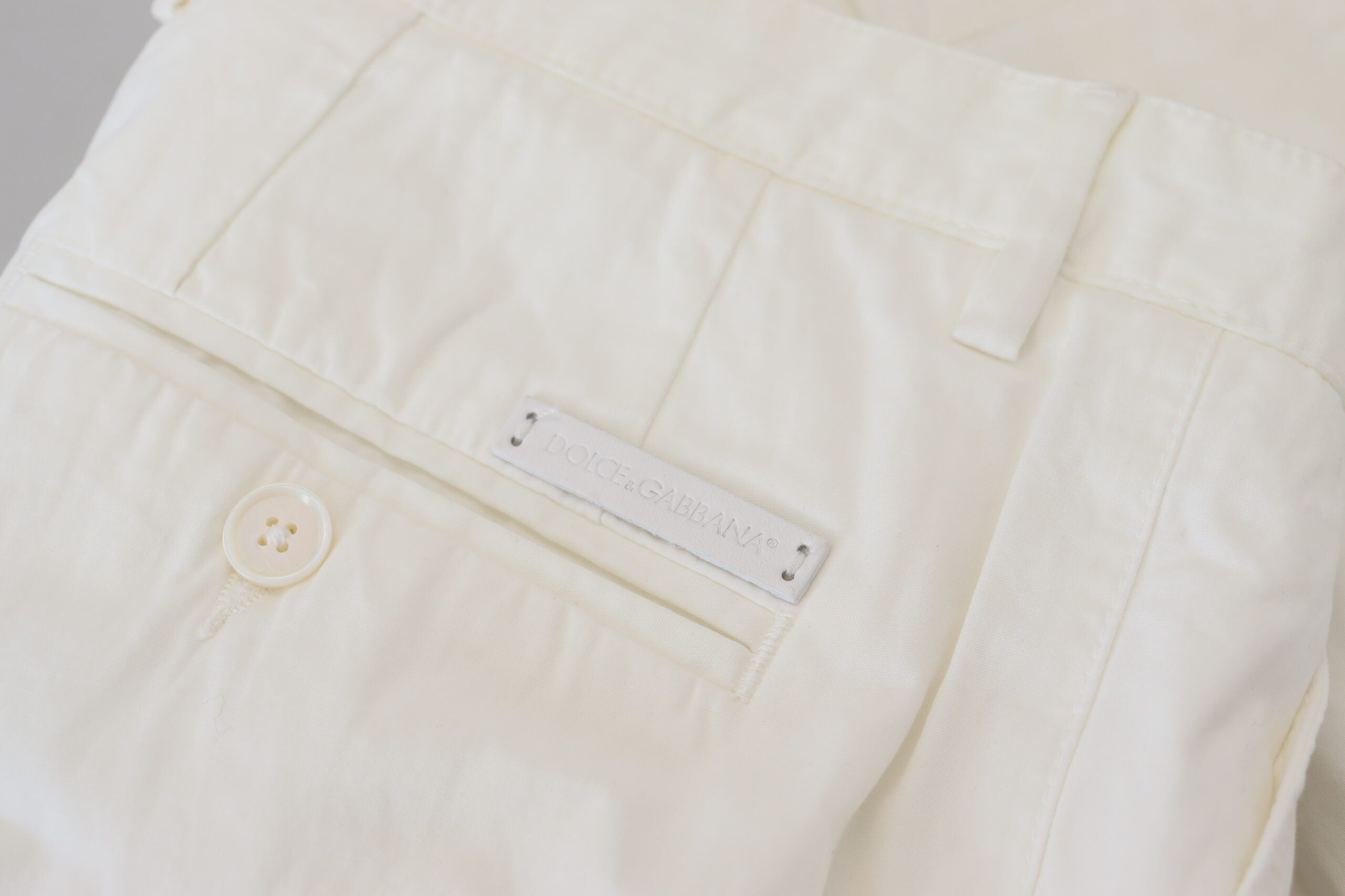 White cotton skinny chino pants by Dolce & Gabbana, shown on a model with a close-up view of the fitted design and clean fabric.
