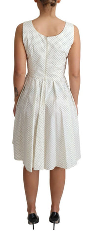 White cotton A-line dress with black polka dots from Dolce & Gabbana, featuring a fitted bodice and flowing skirt.