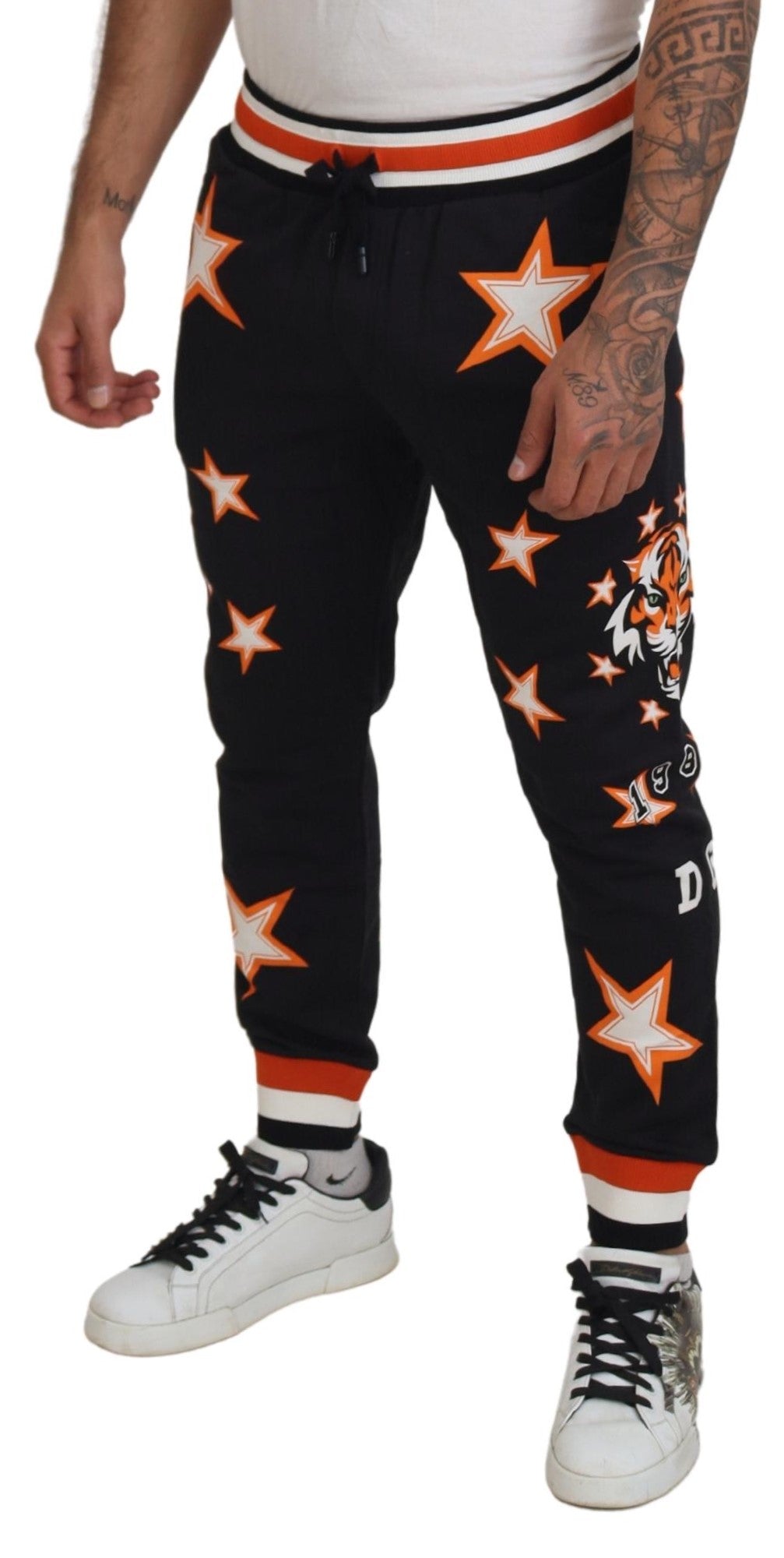 Black and orange star-patterned sport trousers by Dolce & Gabbana, featuring a relaxed fit and athletic style.
