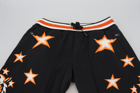 Black and orange star-patterned Dolce & Gabbana sport trousers, athletic pants with bold star design, relaxed fit, and comfortable fabric.