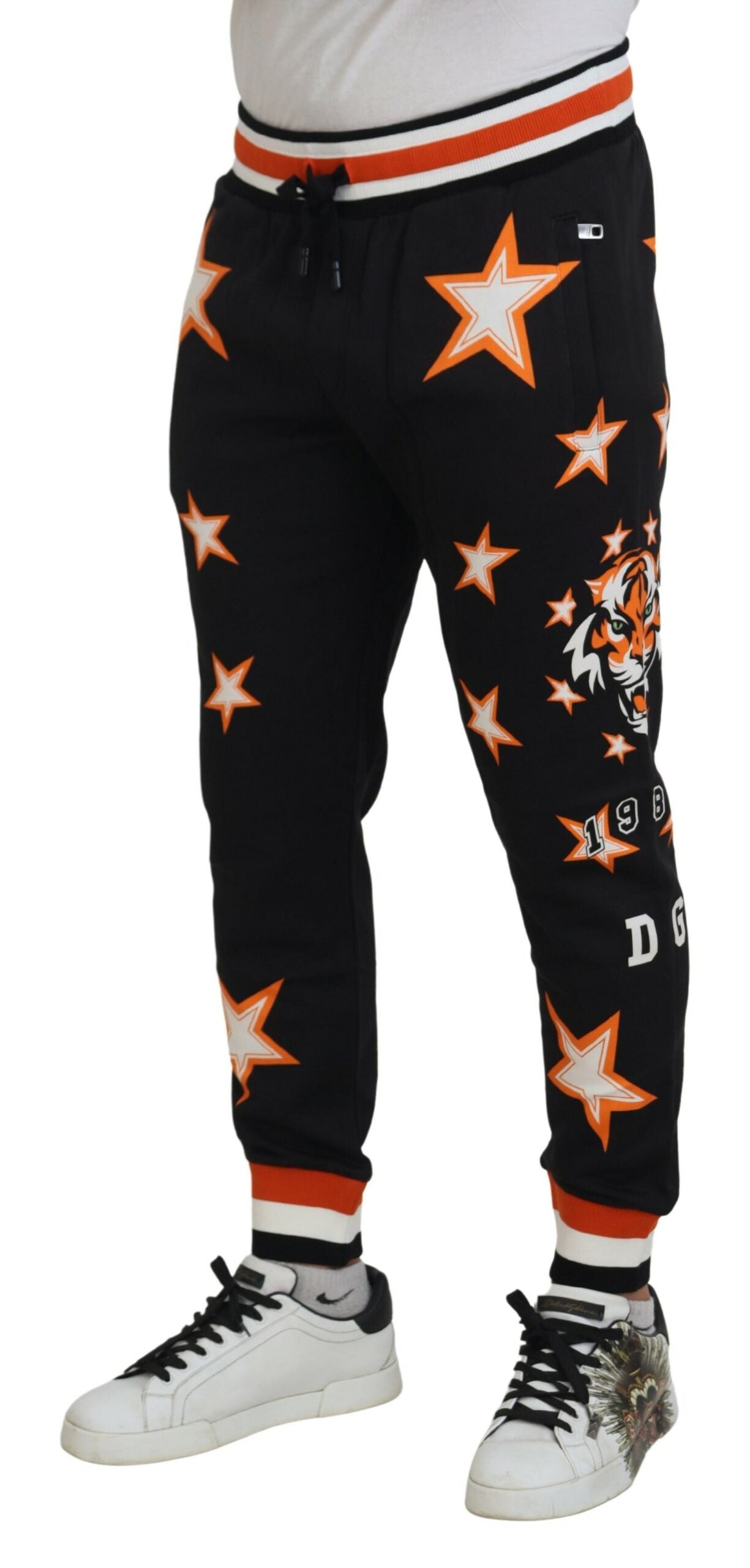 Black and orange star-patterned sport trousers by Dolce & Gabbana, featuring a relaxed fit and athletic design.